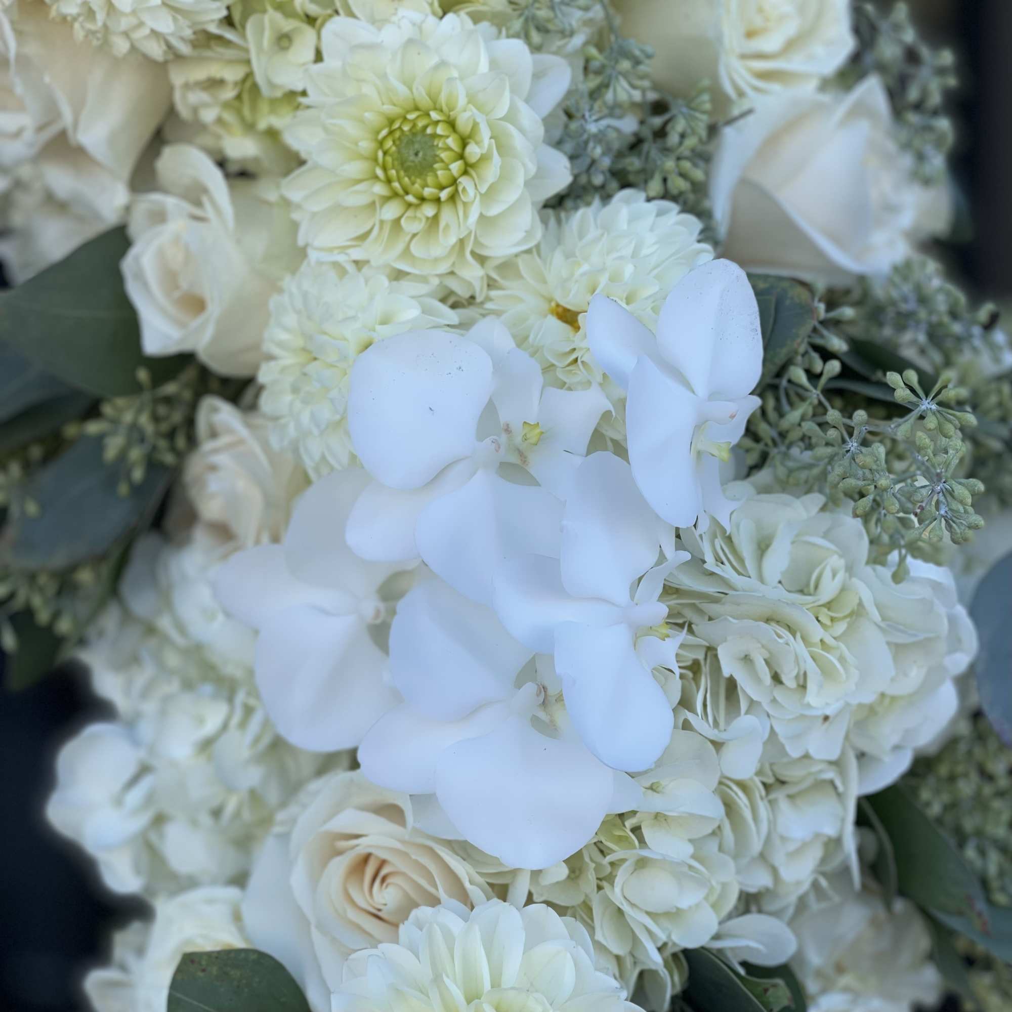 White bouquet with roses, hydrangeas, and orchids