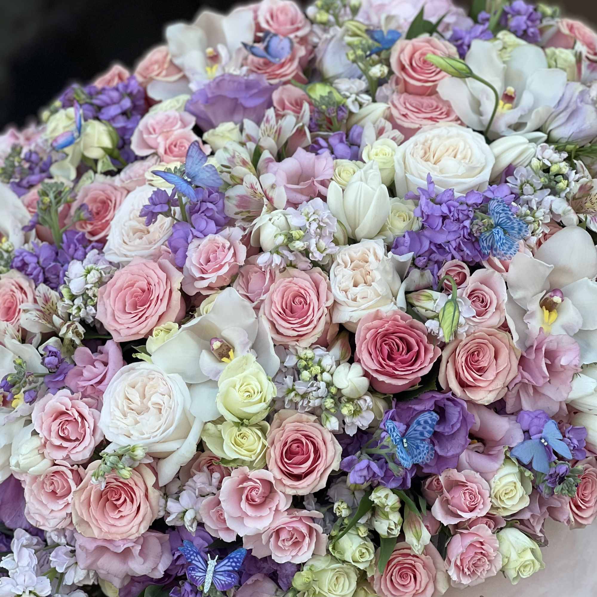 Large bouquet of pink, white, and purple flowers with butterfly accents