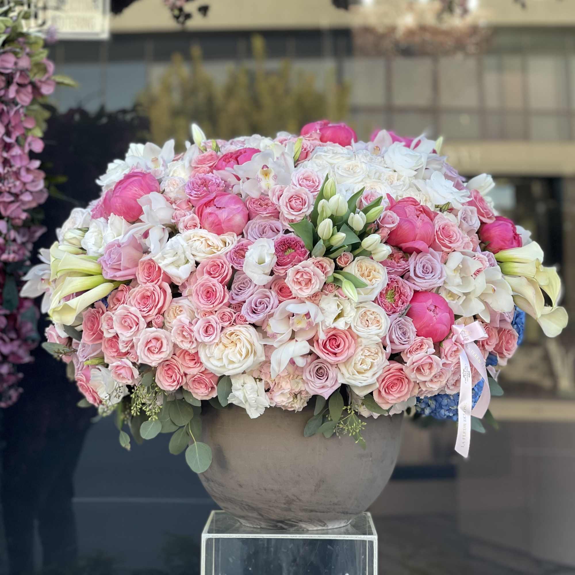 Large pink and white floral arrangement in a gray vase