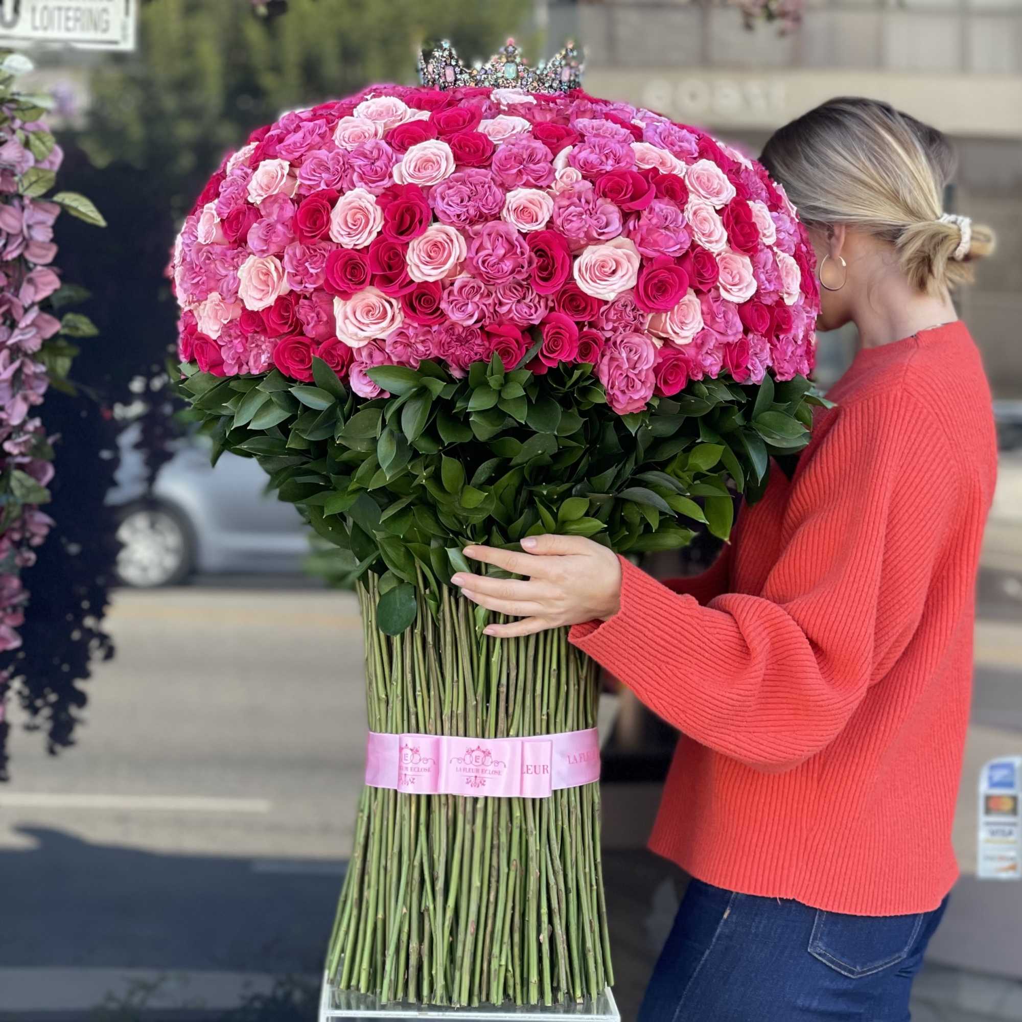 Large bouquet of pink and red roses with a crown topper