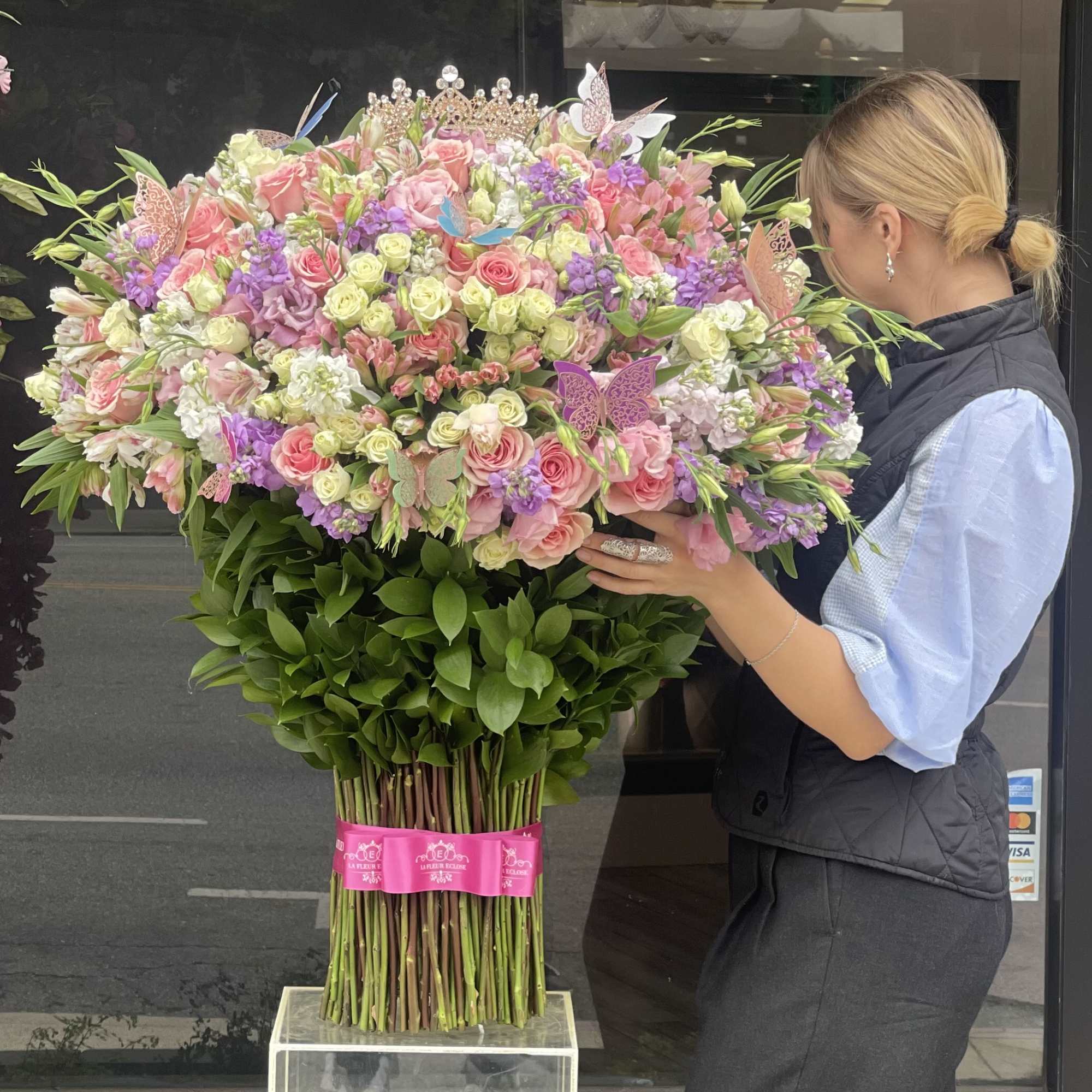 Large pastel bouquet with roses, lilac flowers, and butterfly decorations