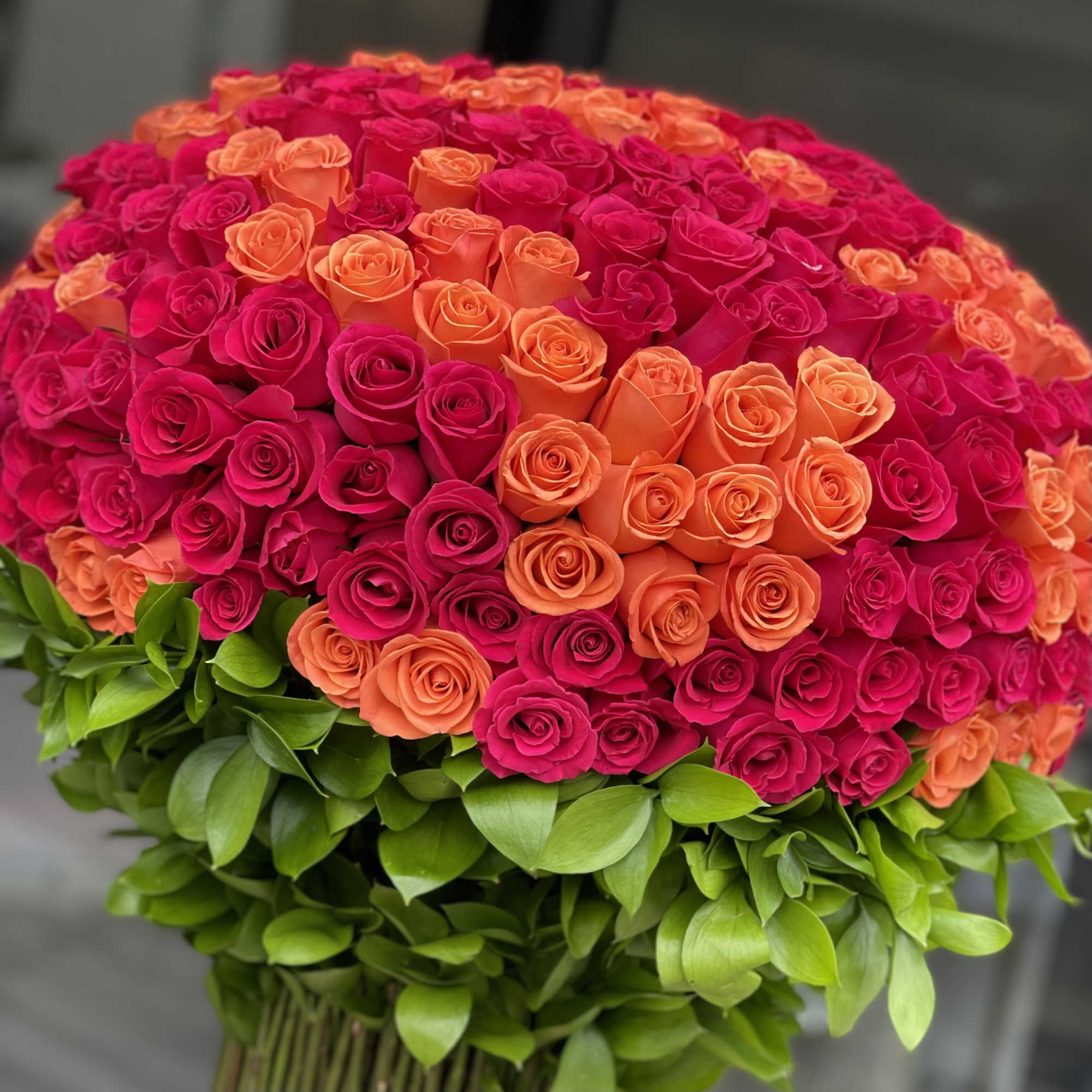 Large bouquet of pink and orange roses with green foliage