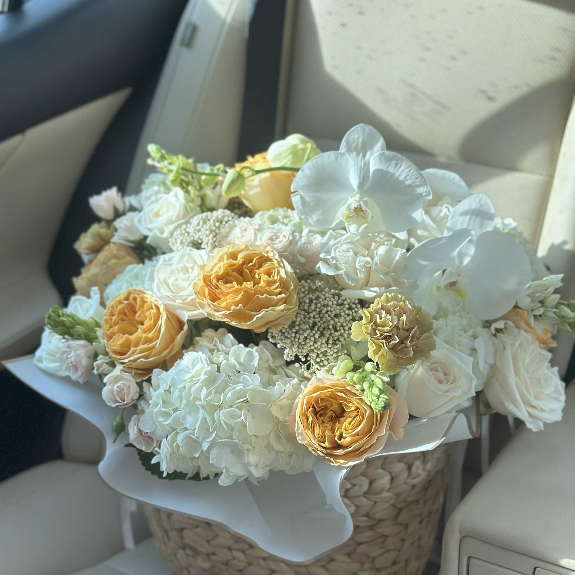 Bouquet of white and peach flowers in a woven basket