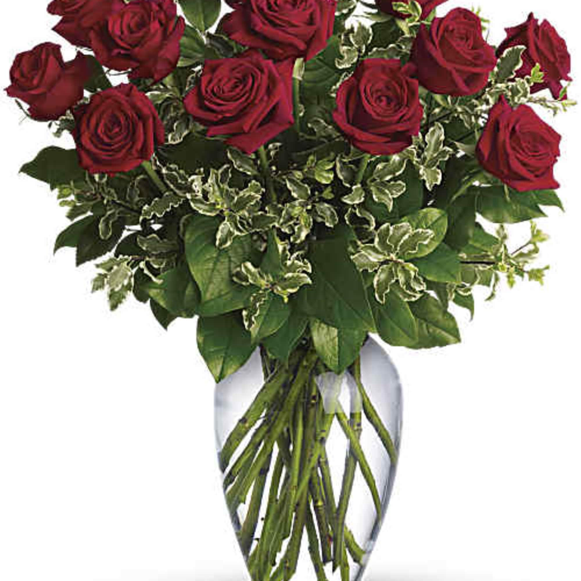Red roses arranged in a clear glass vase with variegated greenery