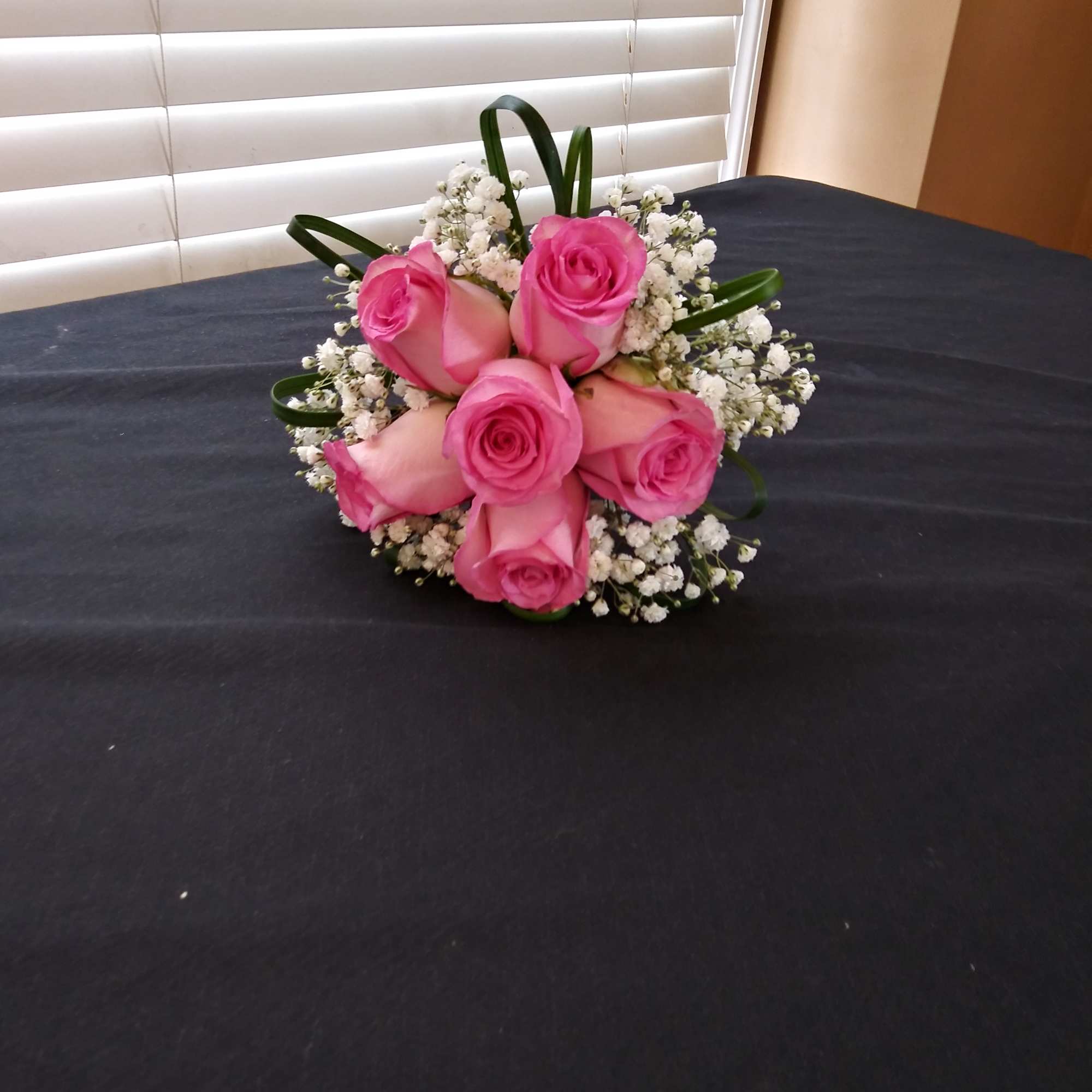 Pink rose bouquet with baby's breath on a dark table