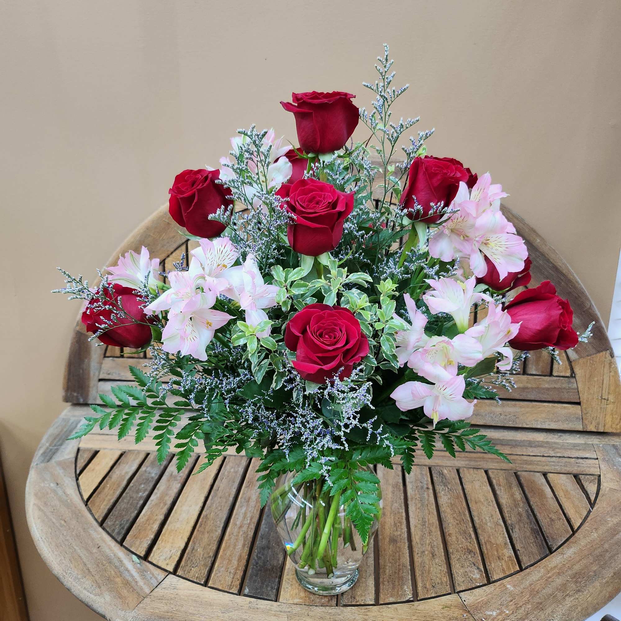 Red roses and pale pink alstroemeria in a clear glass vase