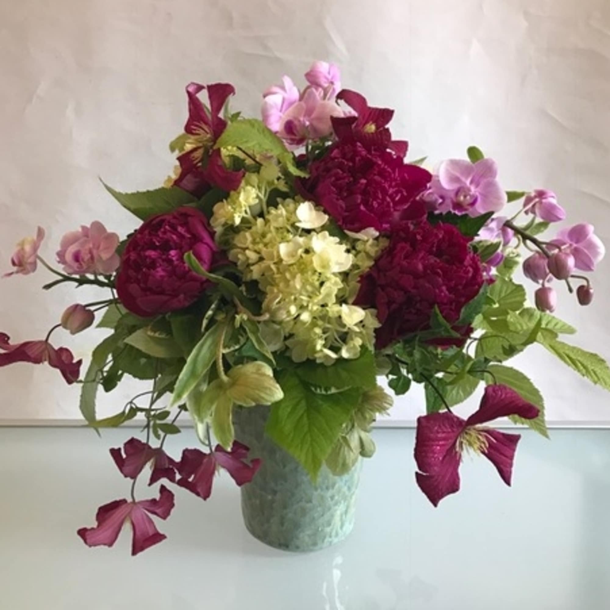 Bouquet of magenta and pink flowers in a green vase