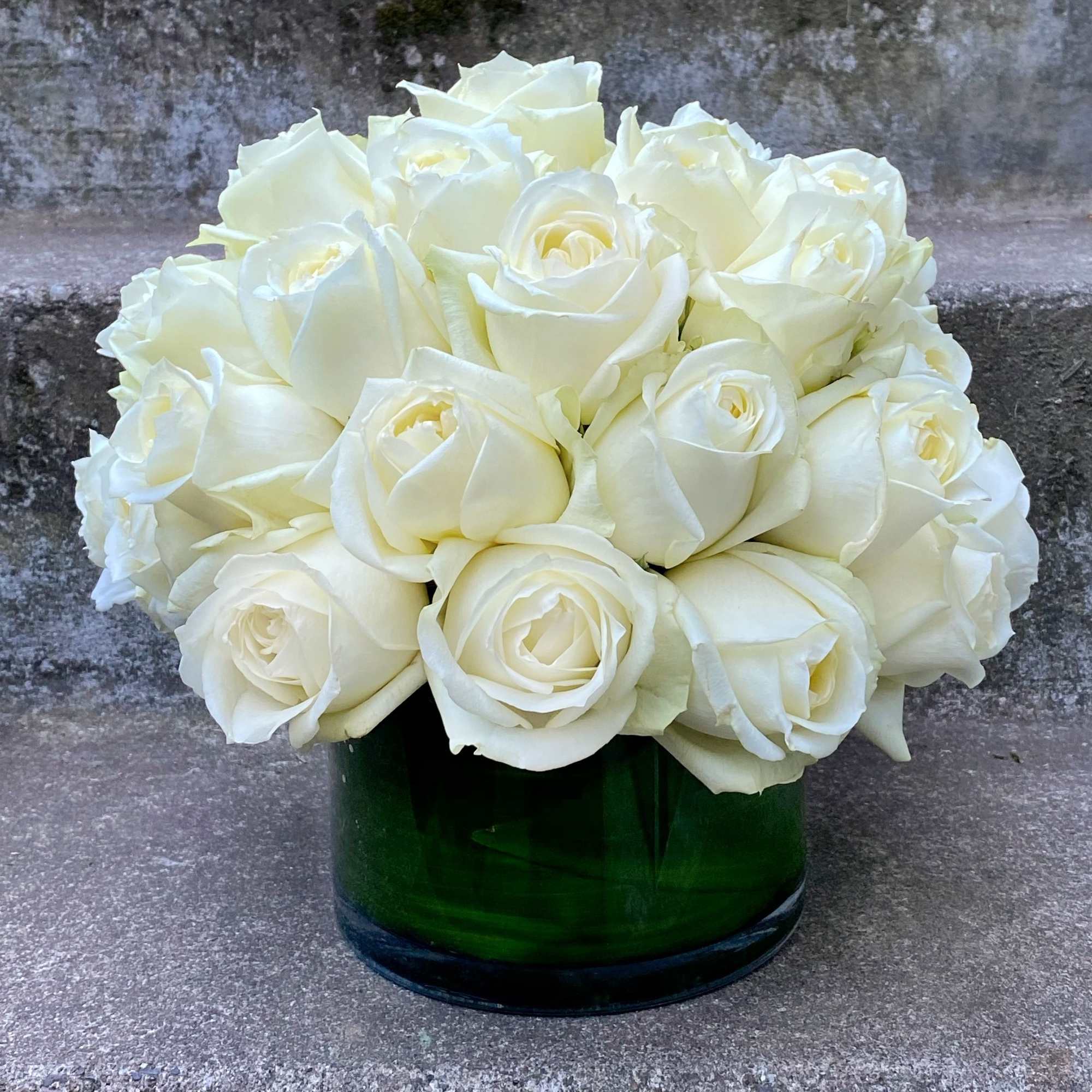 White rose bouquet in a green glass vase