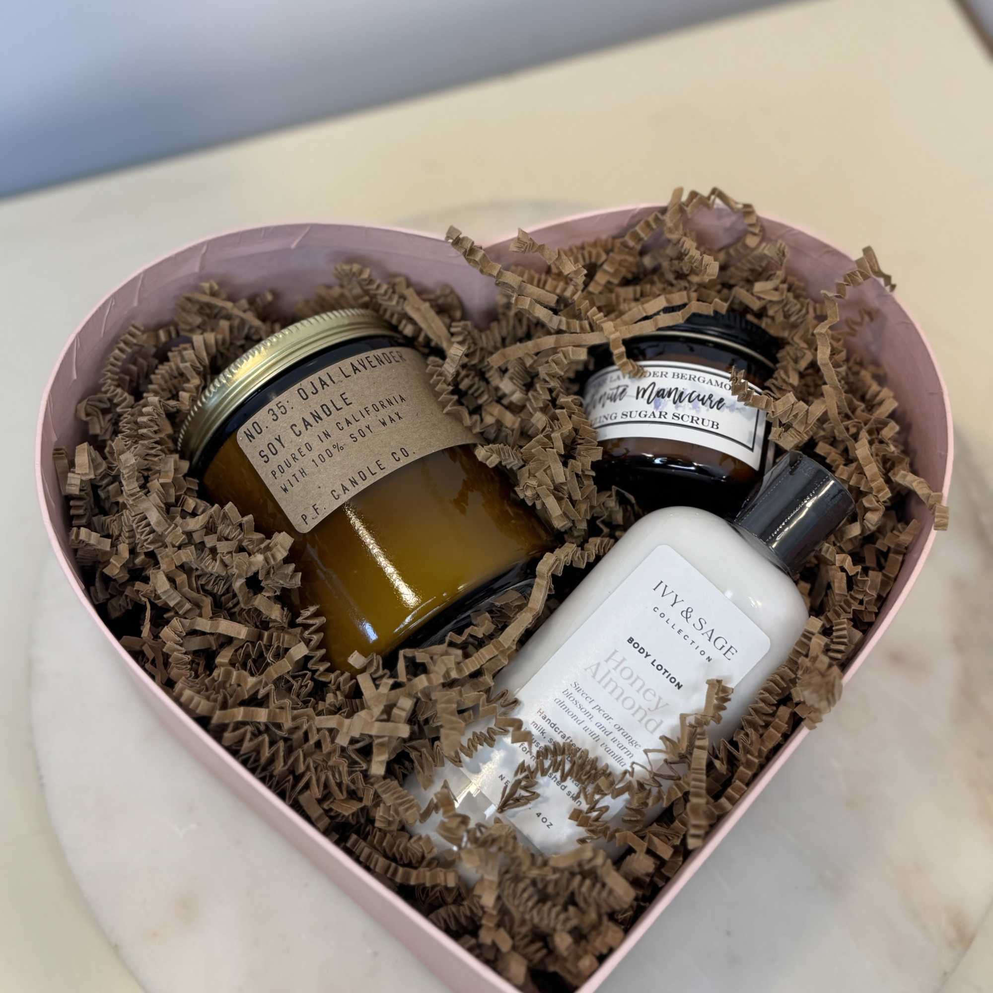 Heart-shaped gift box with candles, body lotion, and sugar scrub