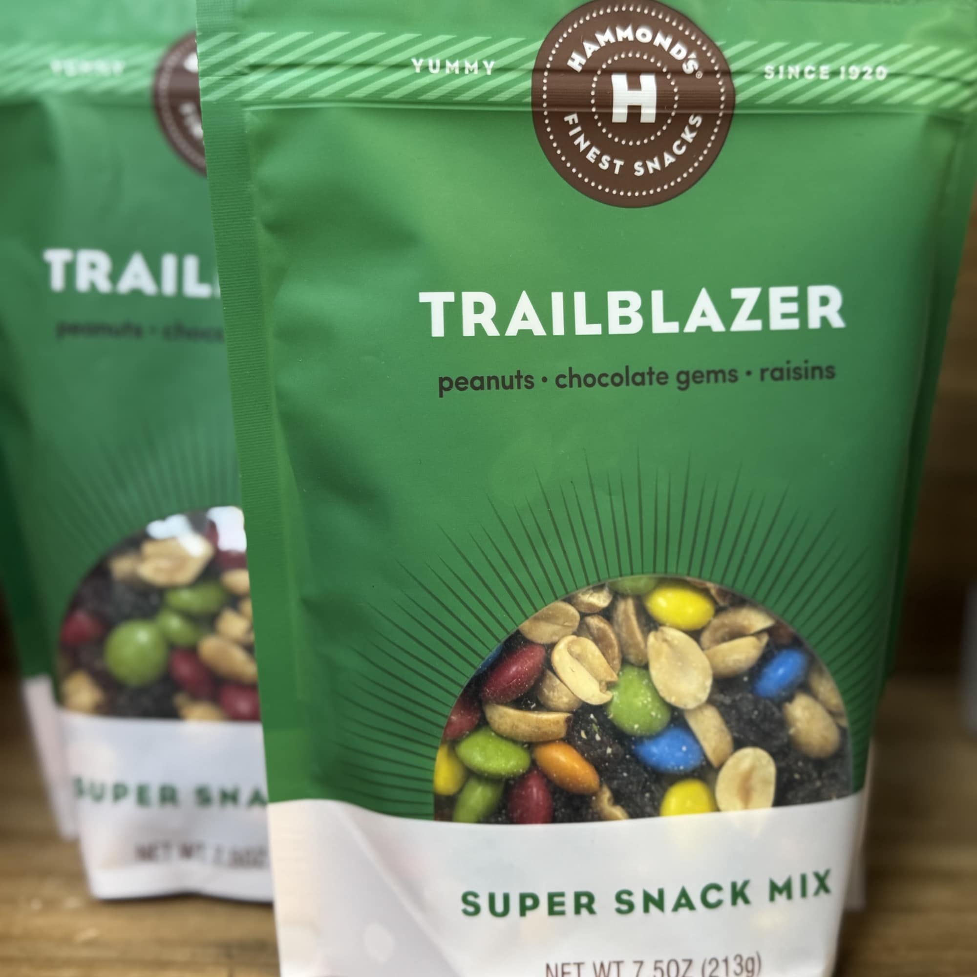 Two green snack mix pouches on a wooden surface