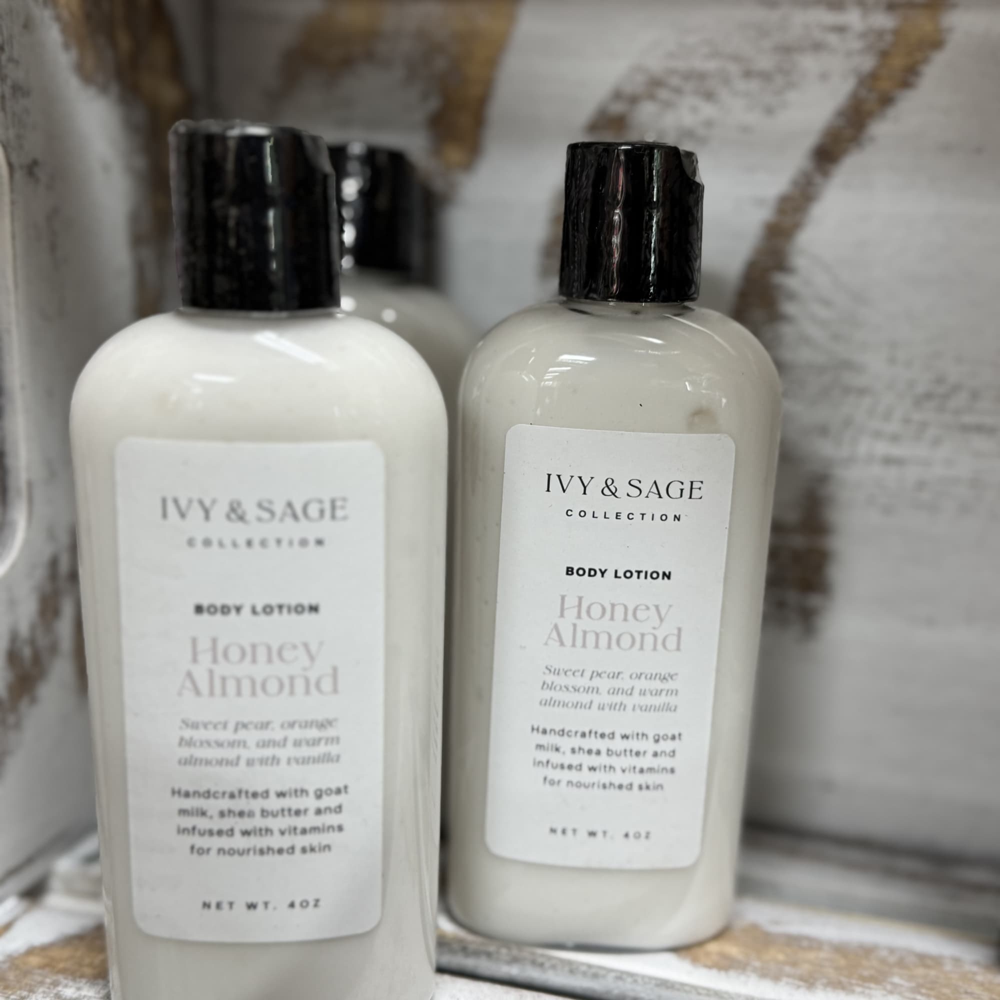 Two bottles of Honey Almond body lotion with black caps