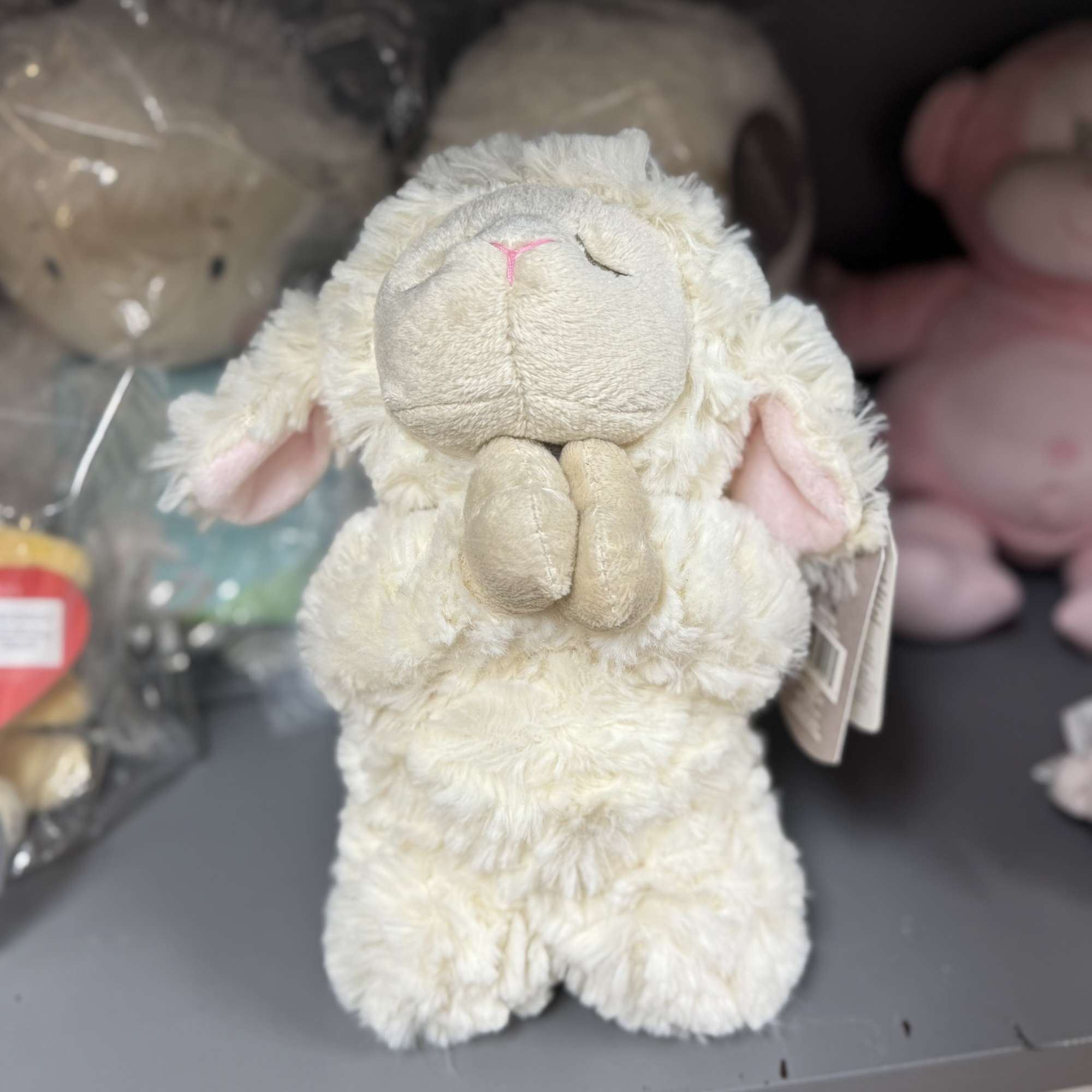 Plush cream-colored lamb toy with pink ears
