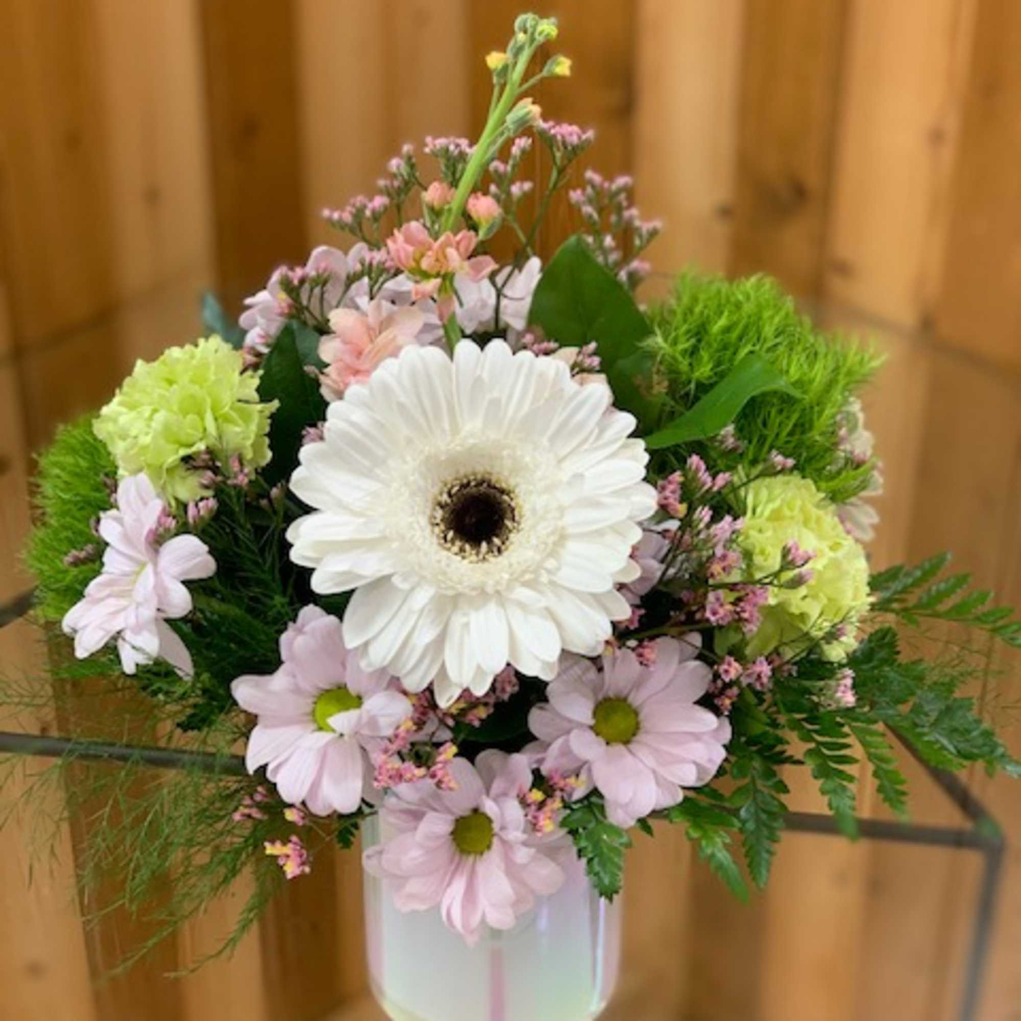 Pink and white flowers arranged in a clear vase