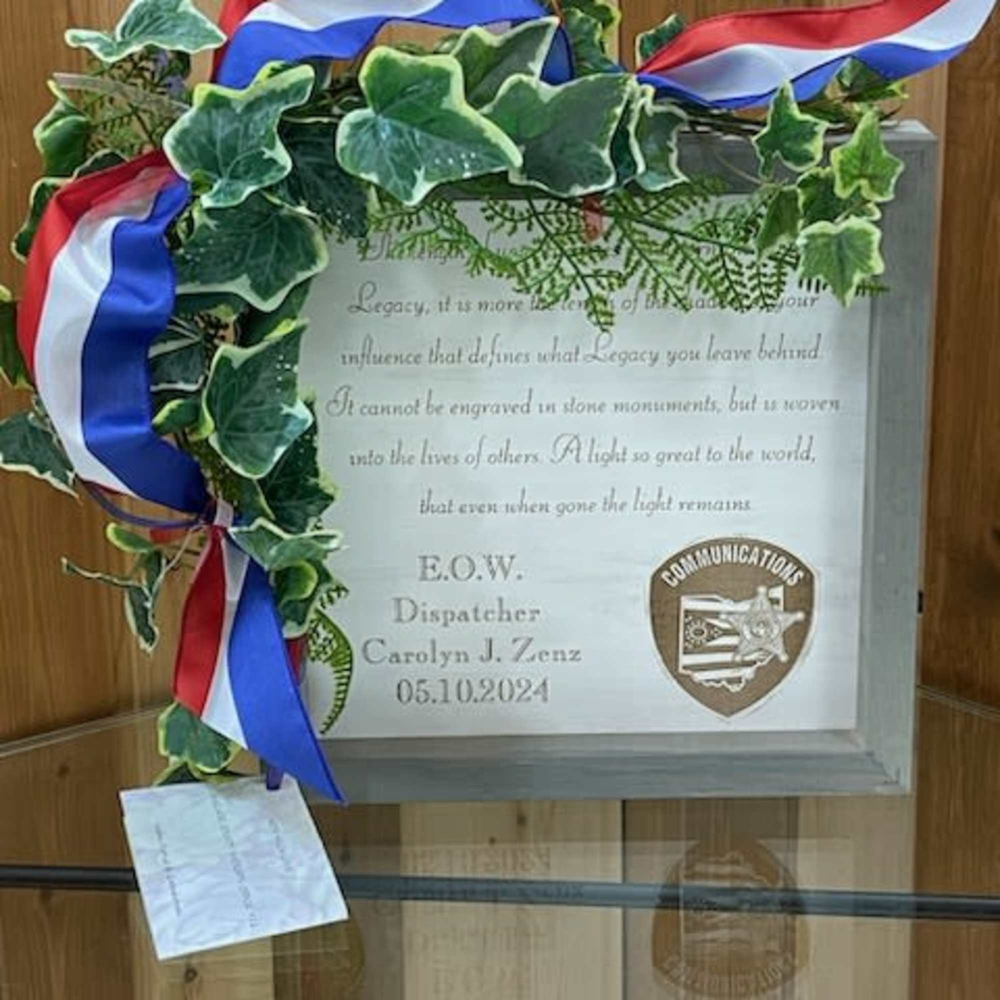 Memorial plaque framed with ivy and red, white, and blue ribbons