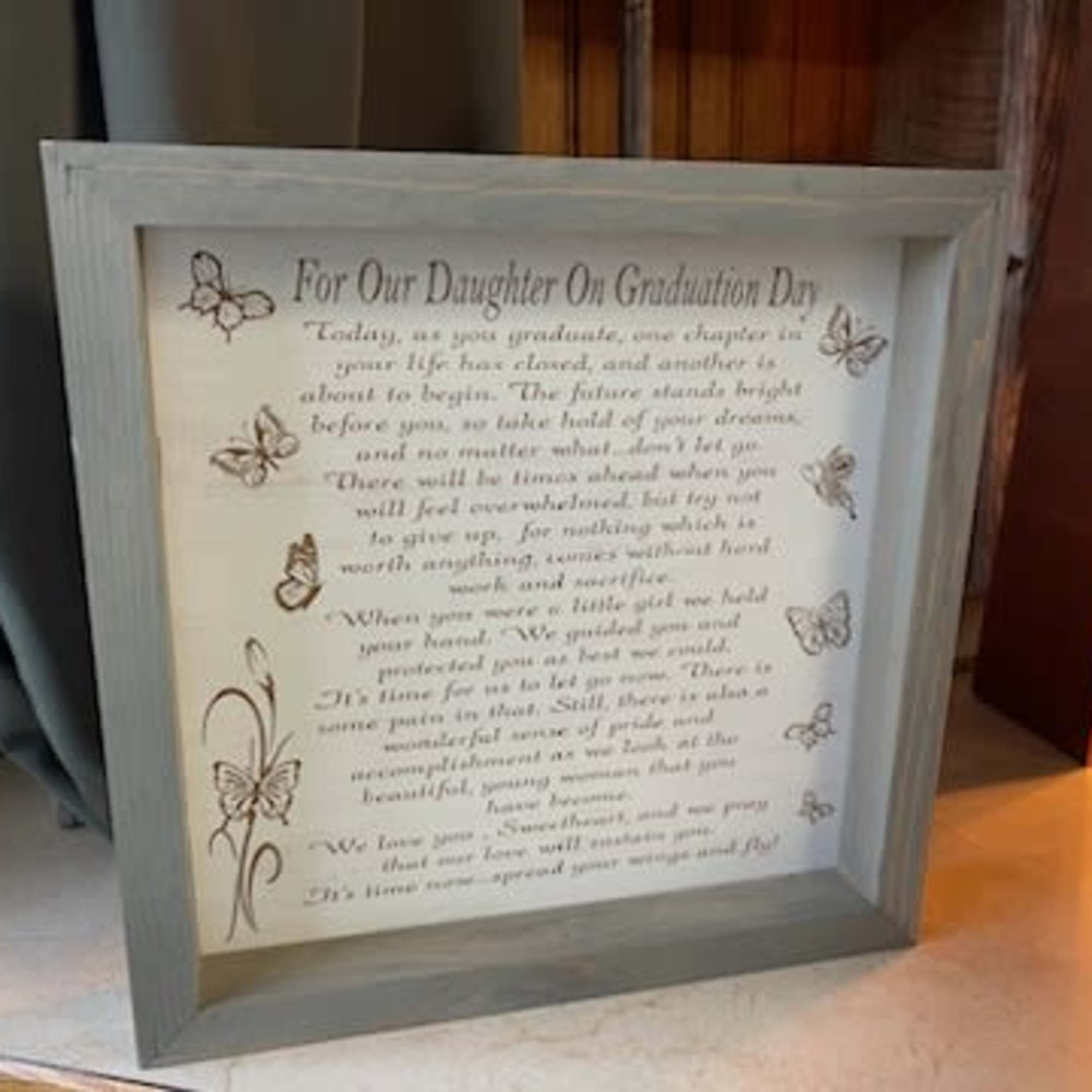 Framed graduation message with butterfly decorations