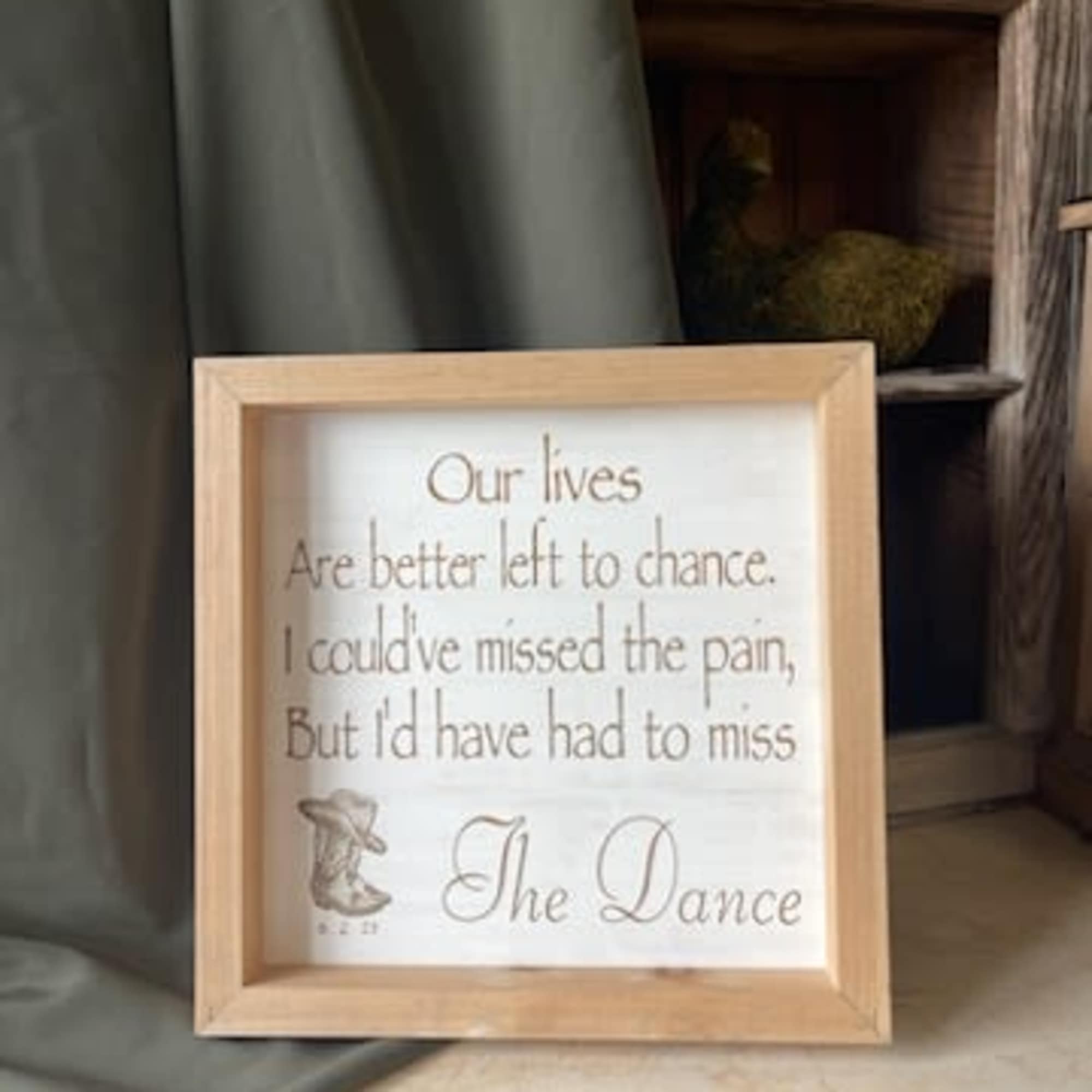 Framed memorial quote sign leaning against a wall