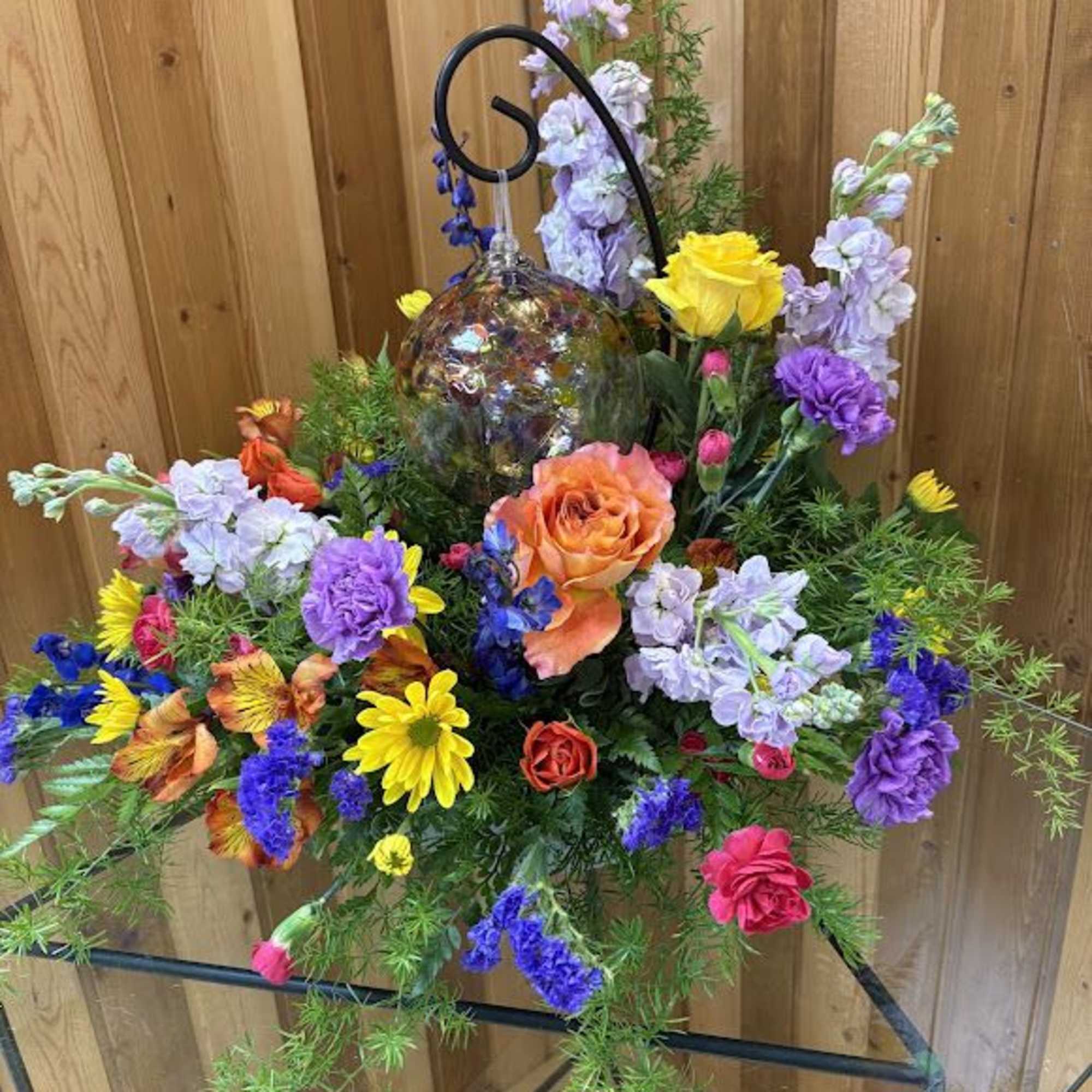 Colorful mixed flower arrangement with a glass ornament centerpiece