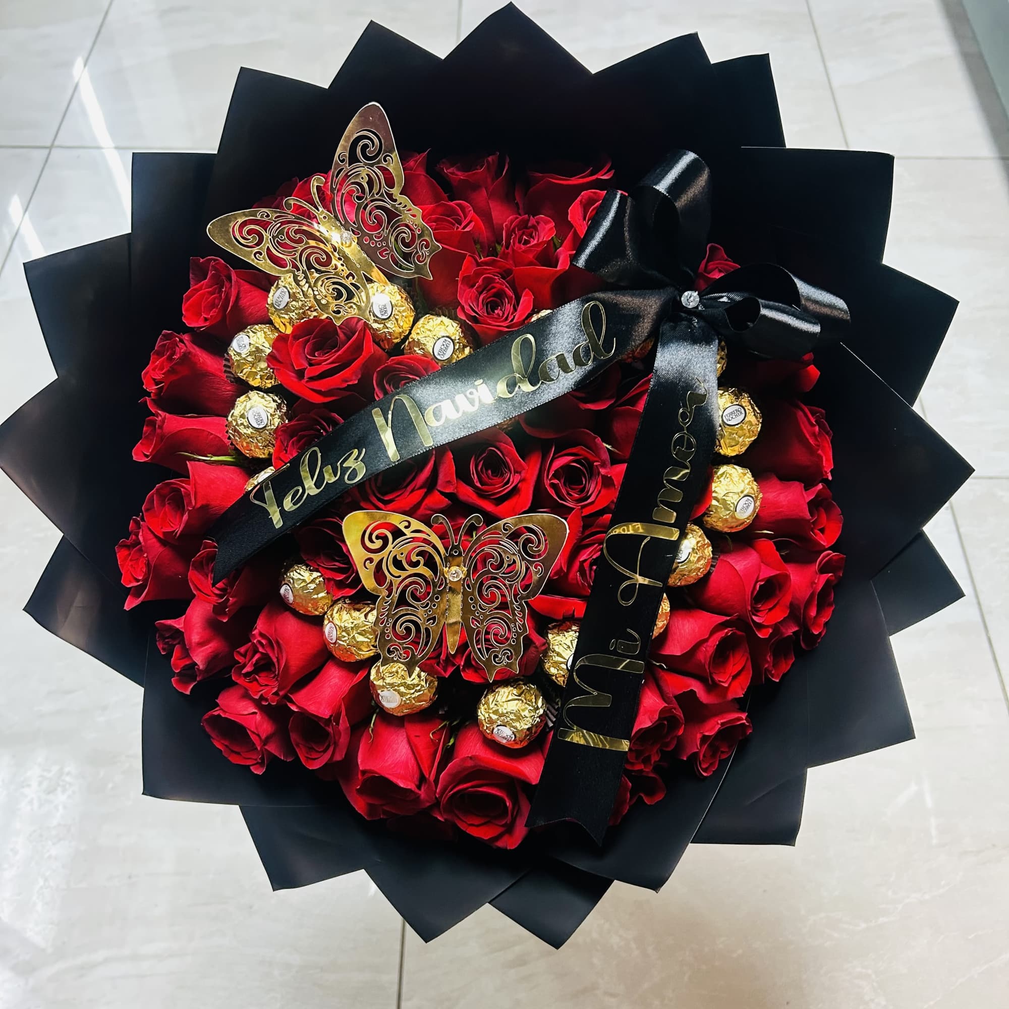 Bouquet of red roses with gold chocolates and black ribbon