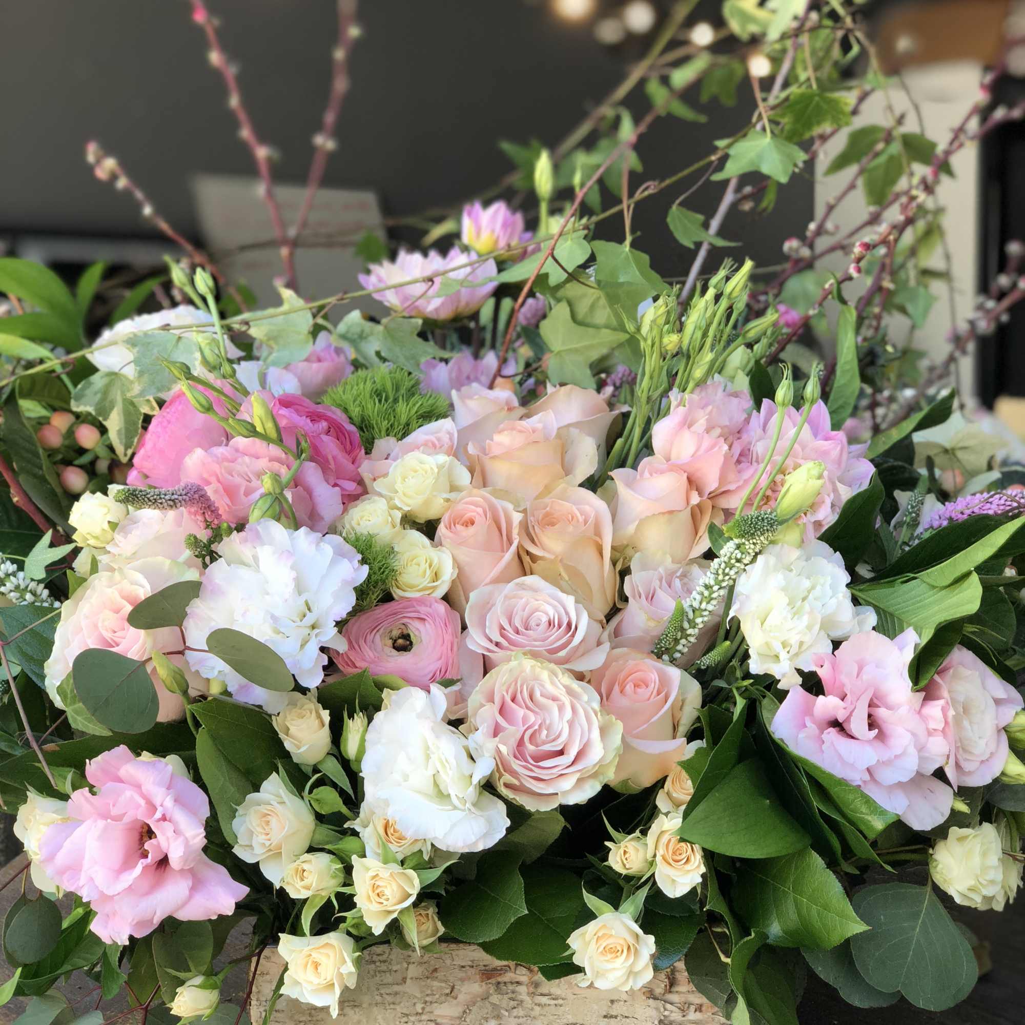 Pastel bouquet of roses and mixed blooms in a wooden box
