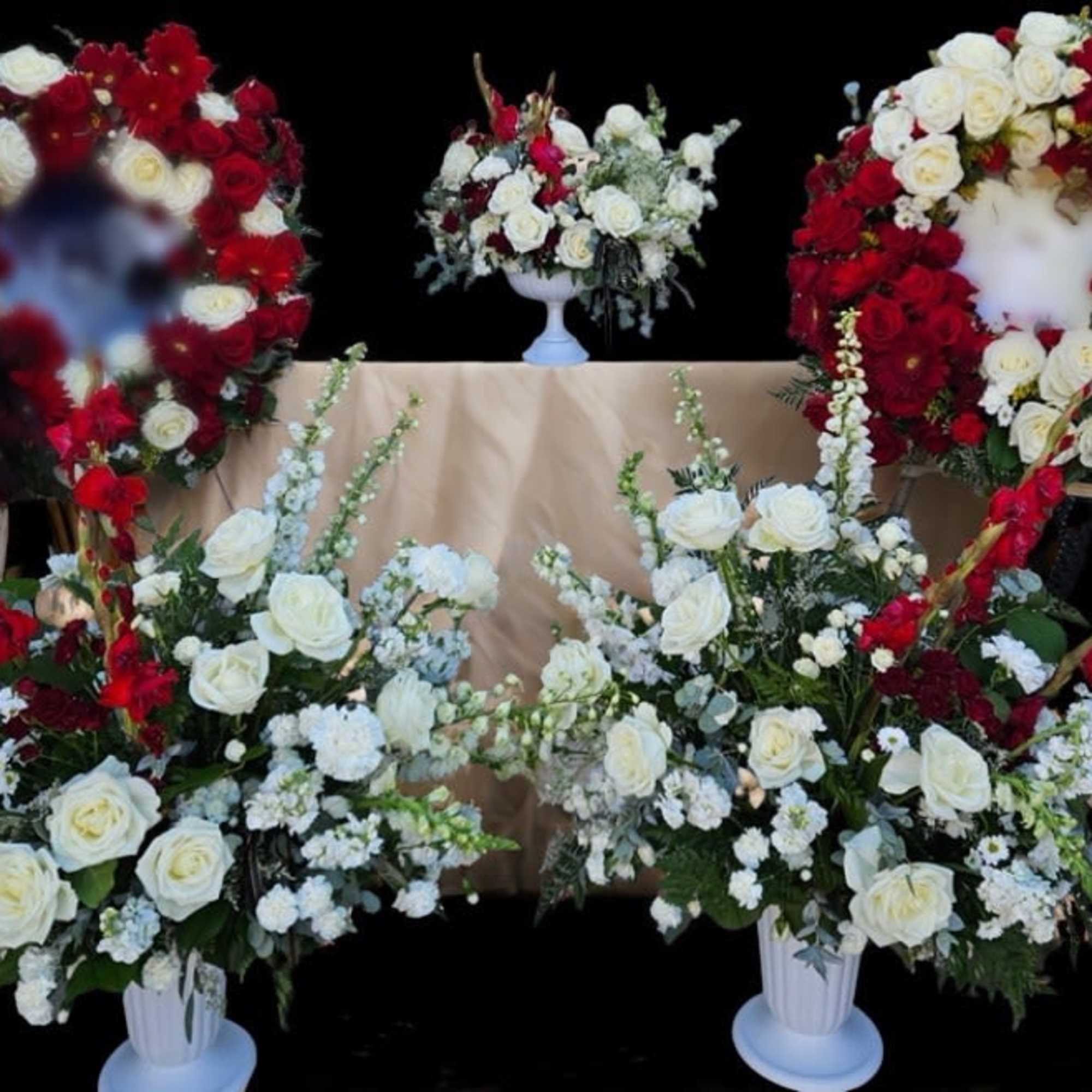 White and red rose funeral wreaths and arrangements on stands