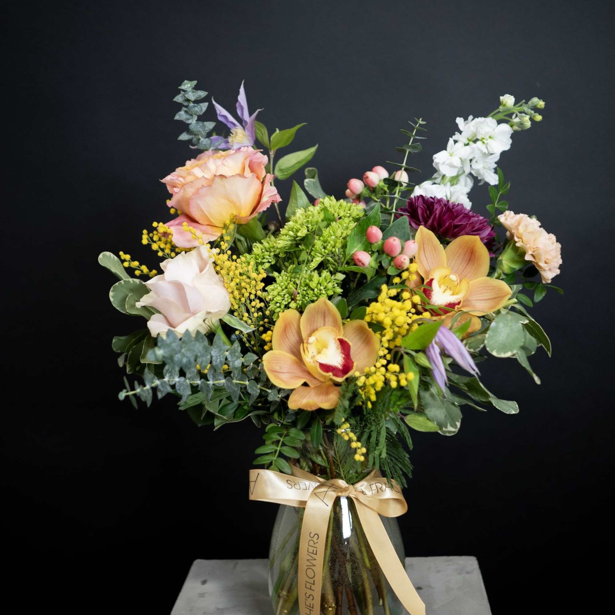 Mixed bouquet in a glass vase with orchids and roses