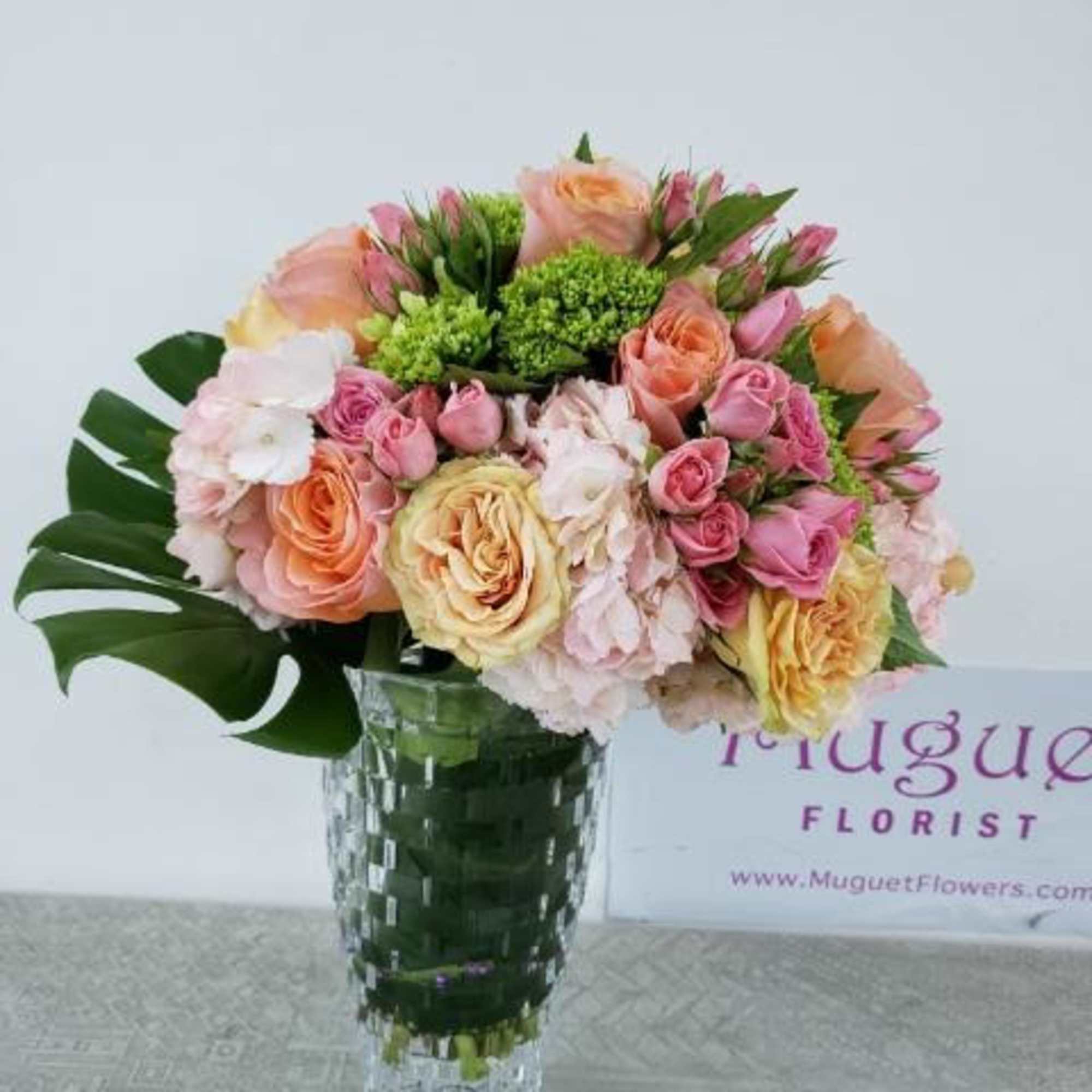 Pink and peach rose bouquet in a clear glass vase