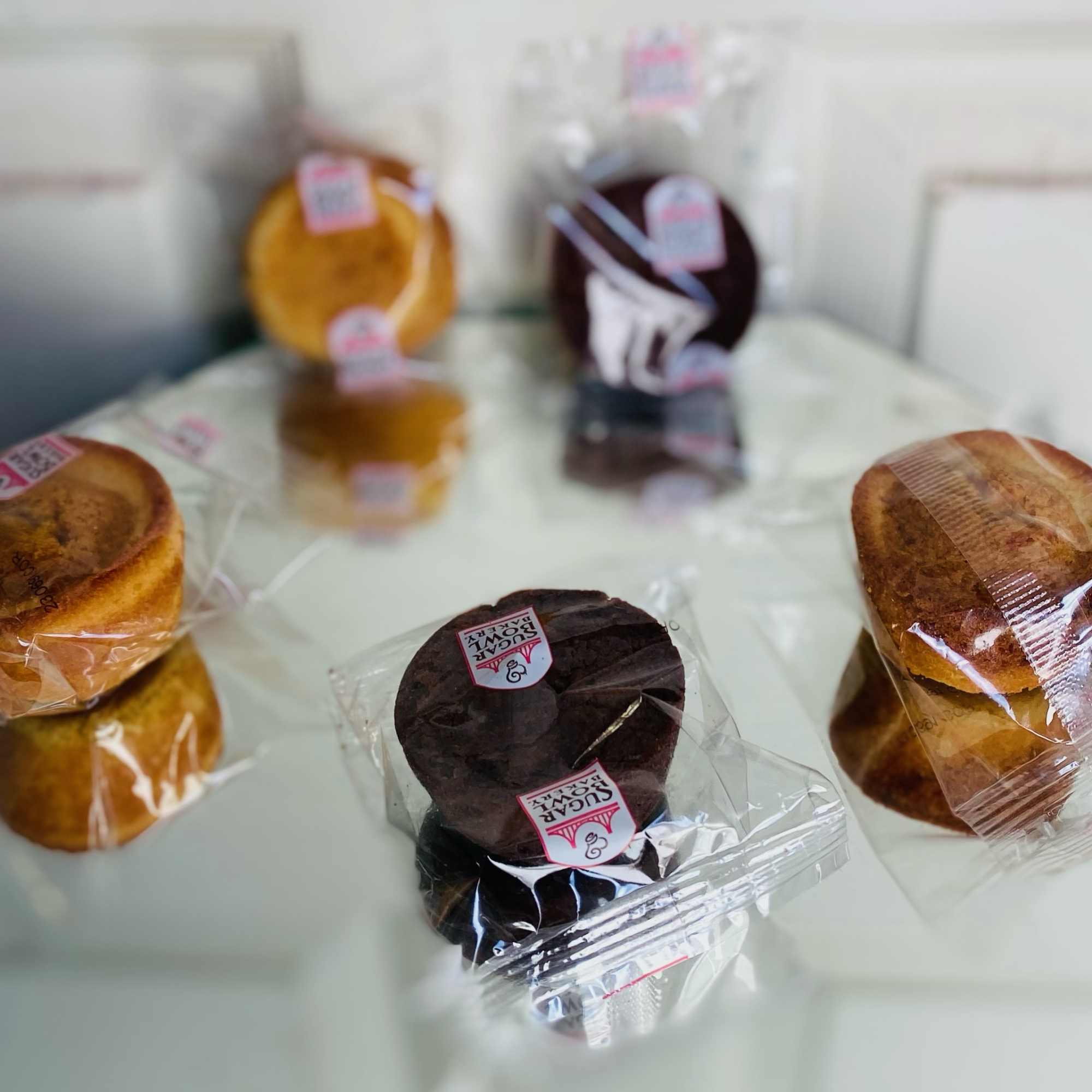 Individually wrapped cupcakes on a glass table