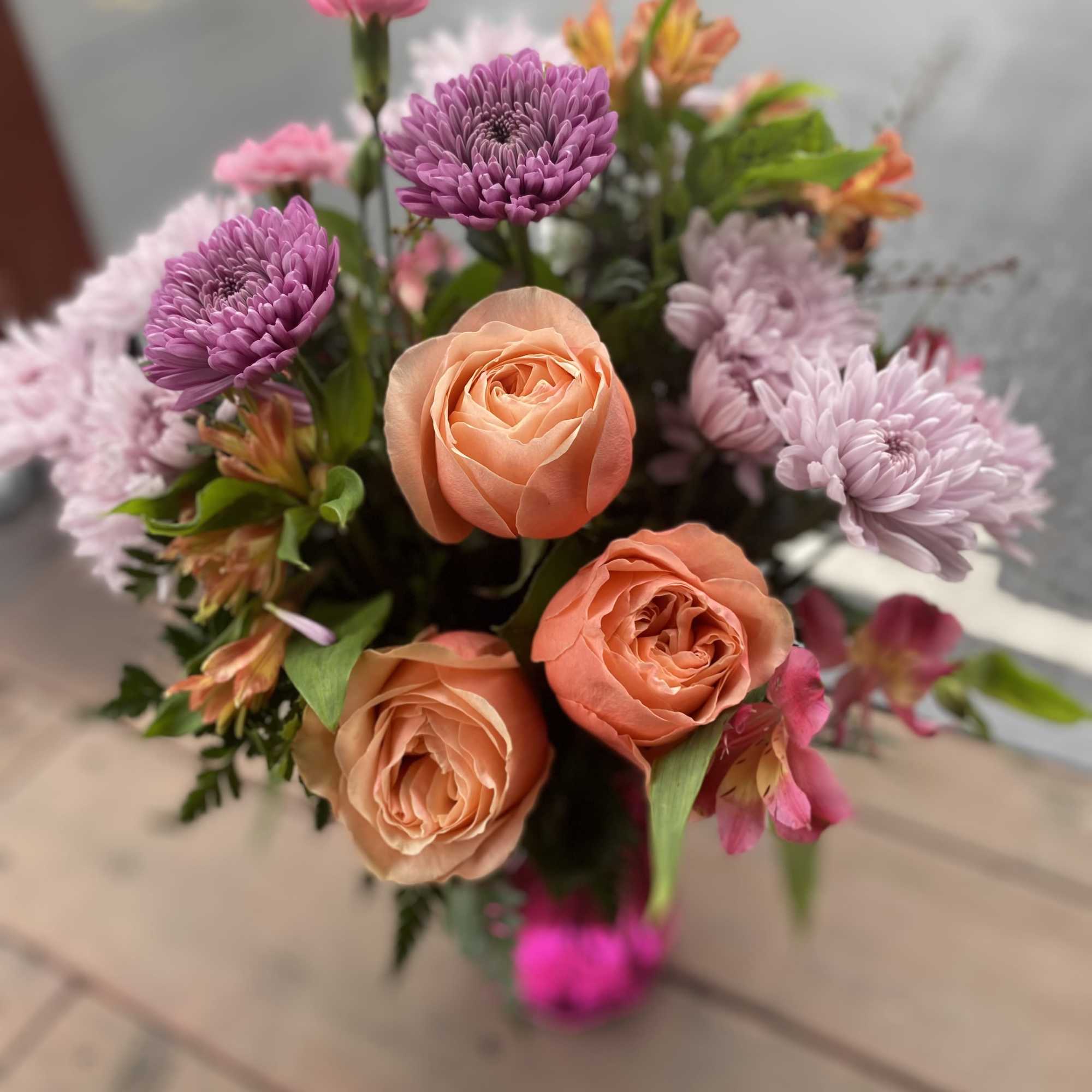 Bouquet of peach roses and purple chrysanthemums