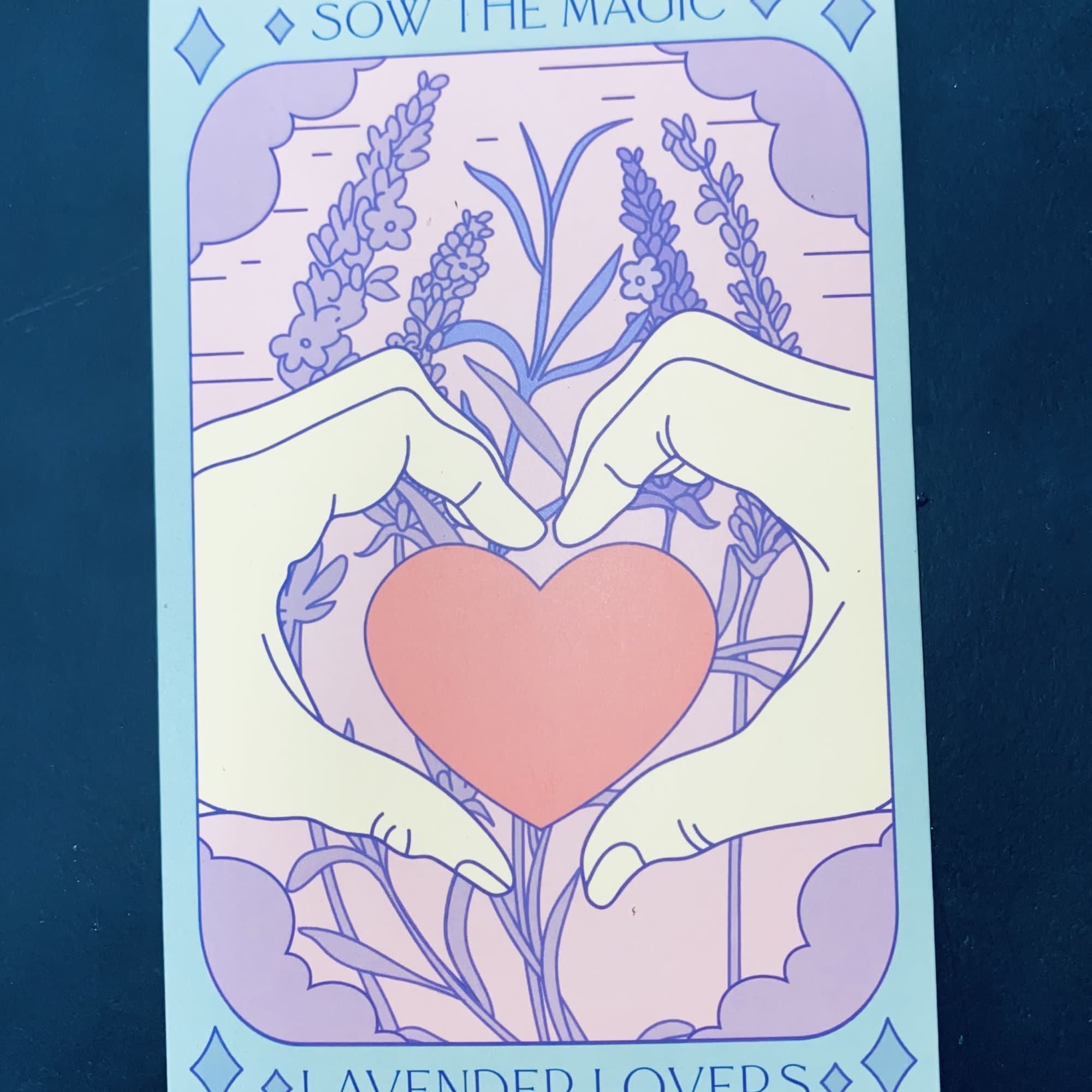 Illustrated hands forming a heart around a pink heart with lavender flowers