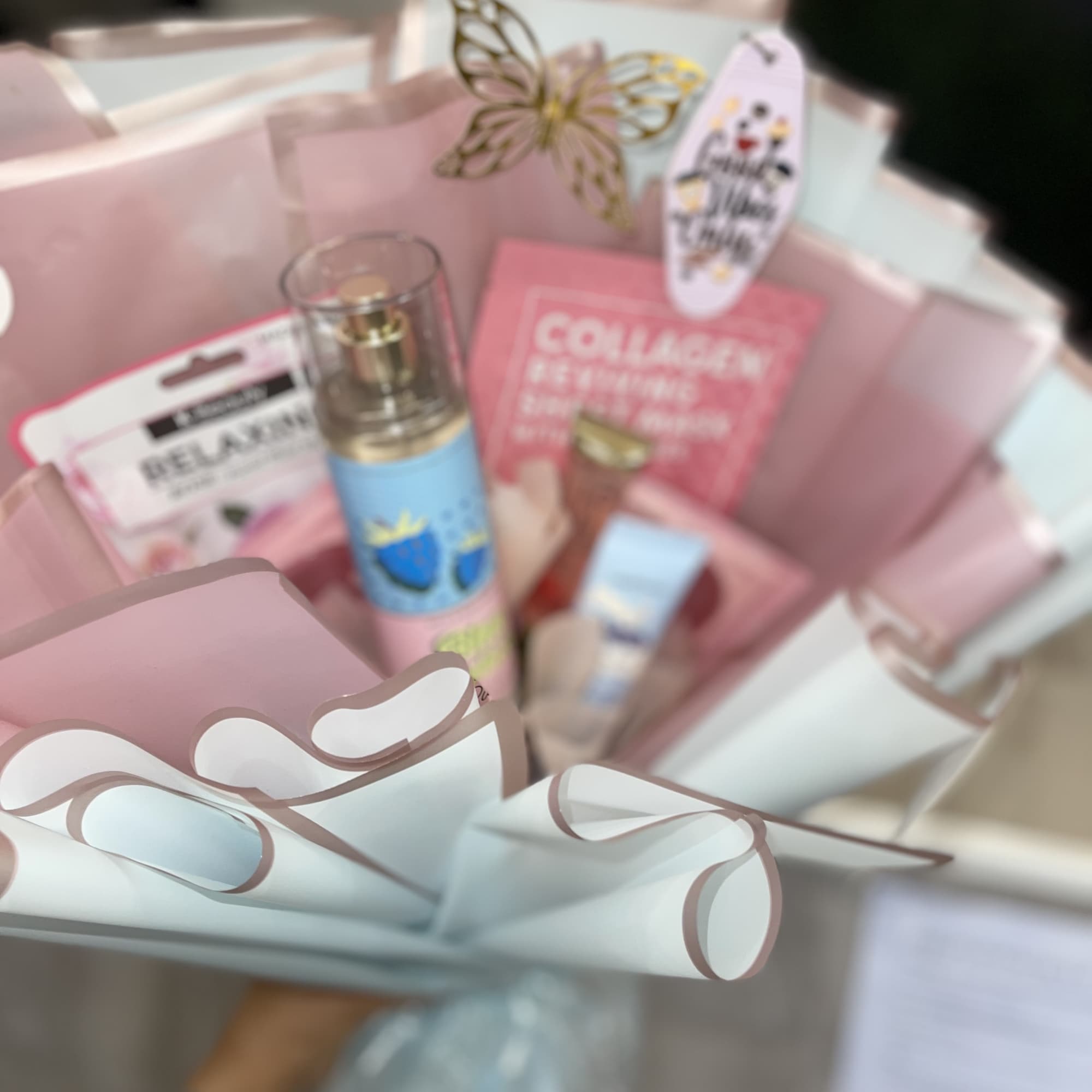 Pink gift basket with skincare items and a butterfly decoration
