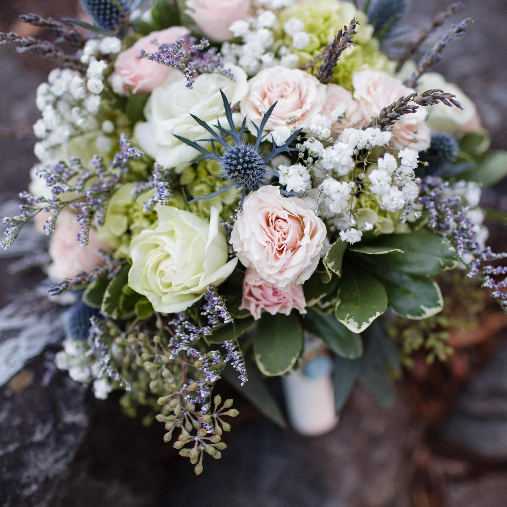 Bouquet of pale pink and white roses with blue thistle accents, photo 2 of 2