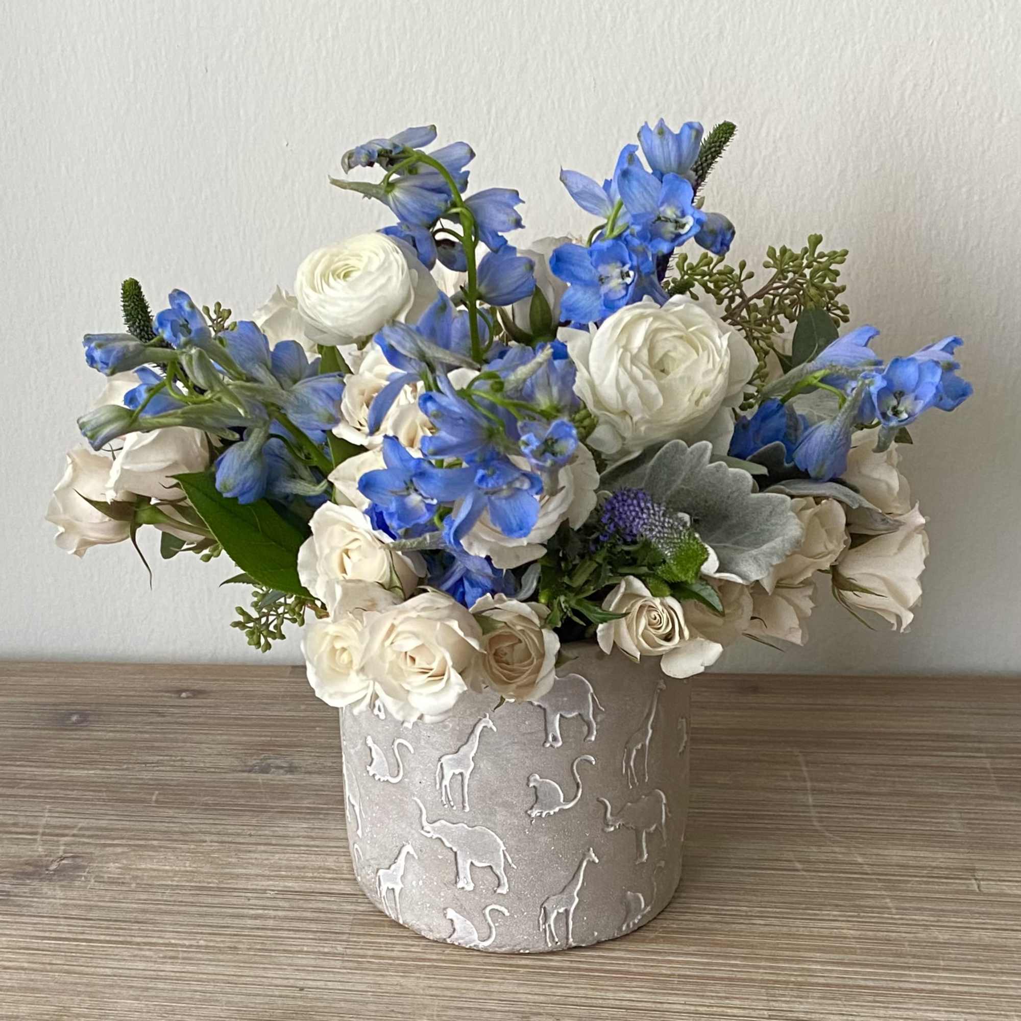 Blue and white floral arrangement in a decorative gray vase