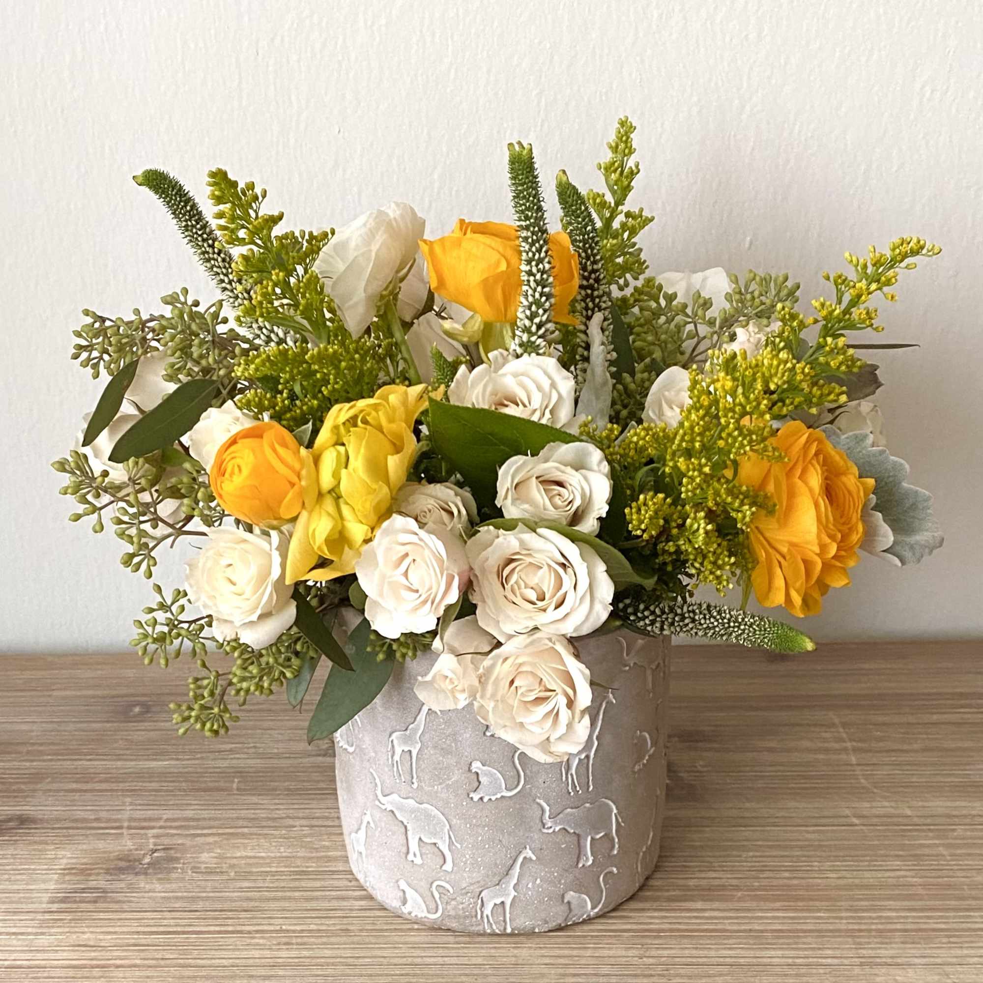 Yellow and white roses in a decorative vase