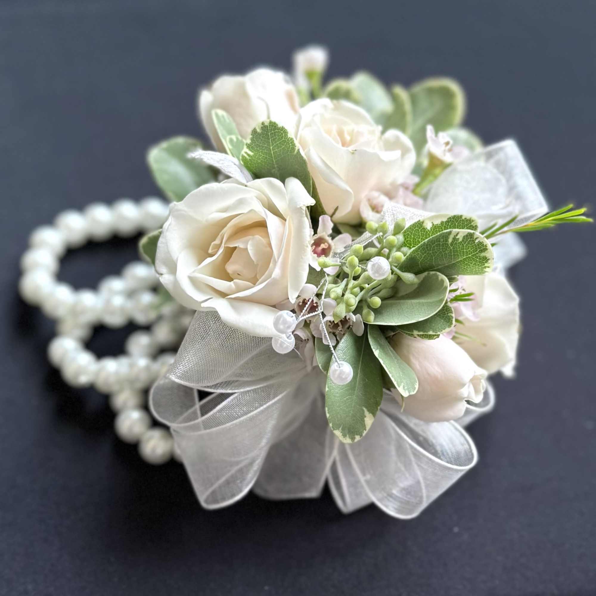 White rose corsage with ribbon and pearl bracelet