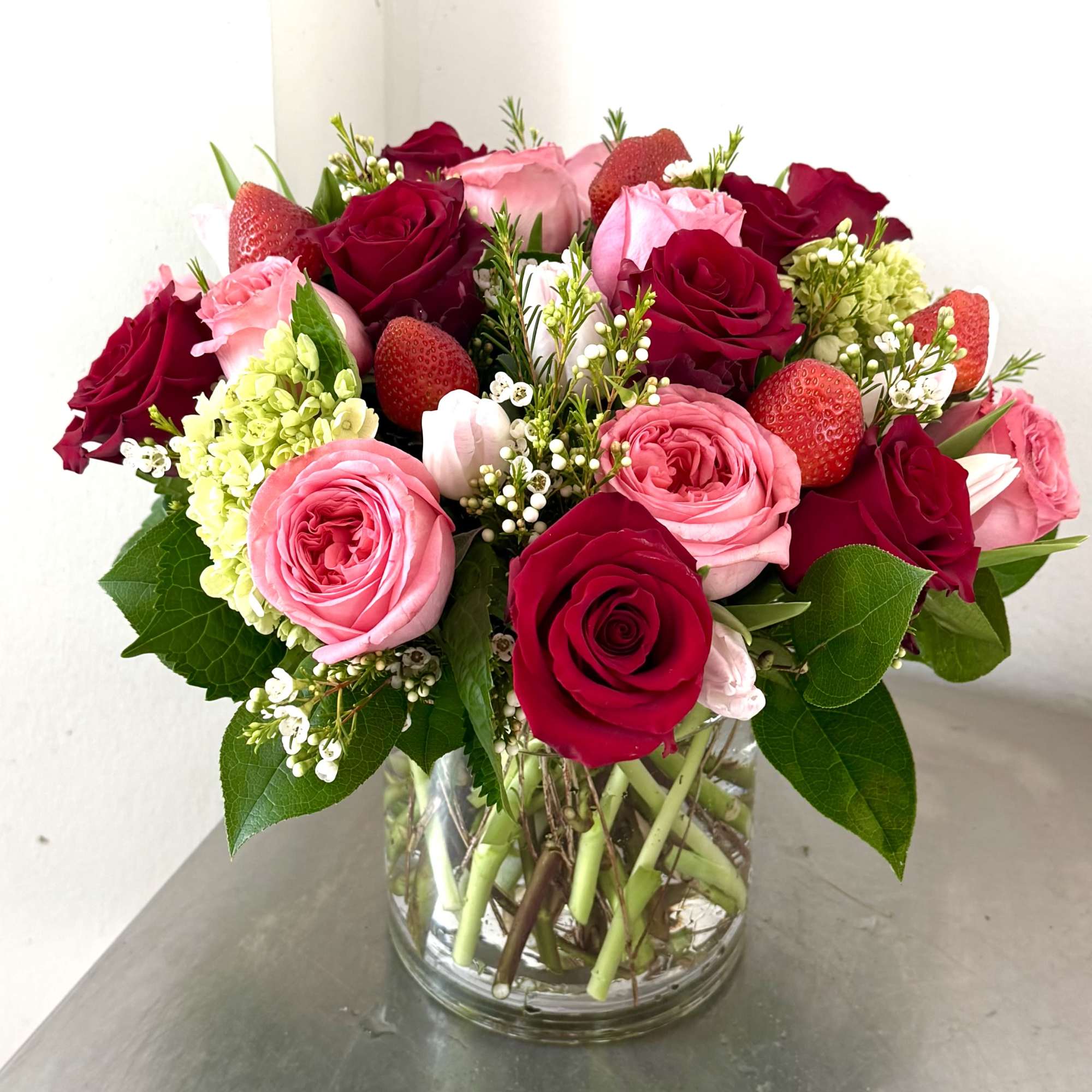 Bouquet of red and pink roses in a clear glass vase