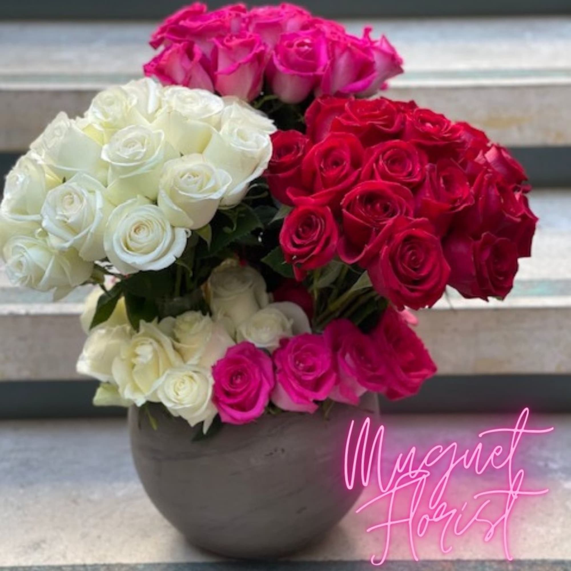 Bouquet of pink, red, and white roses in a round vase