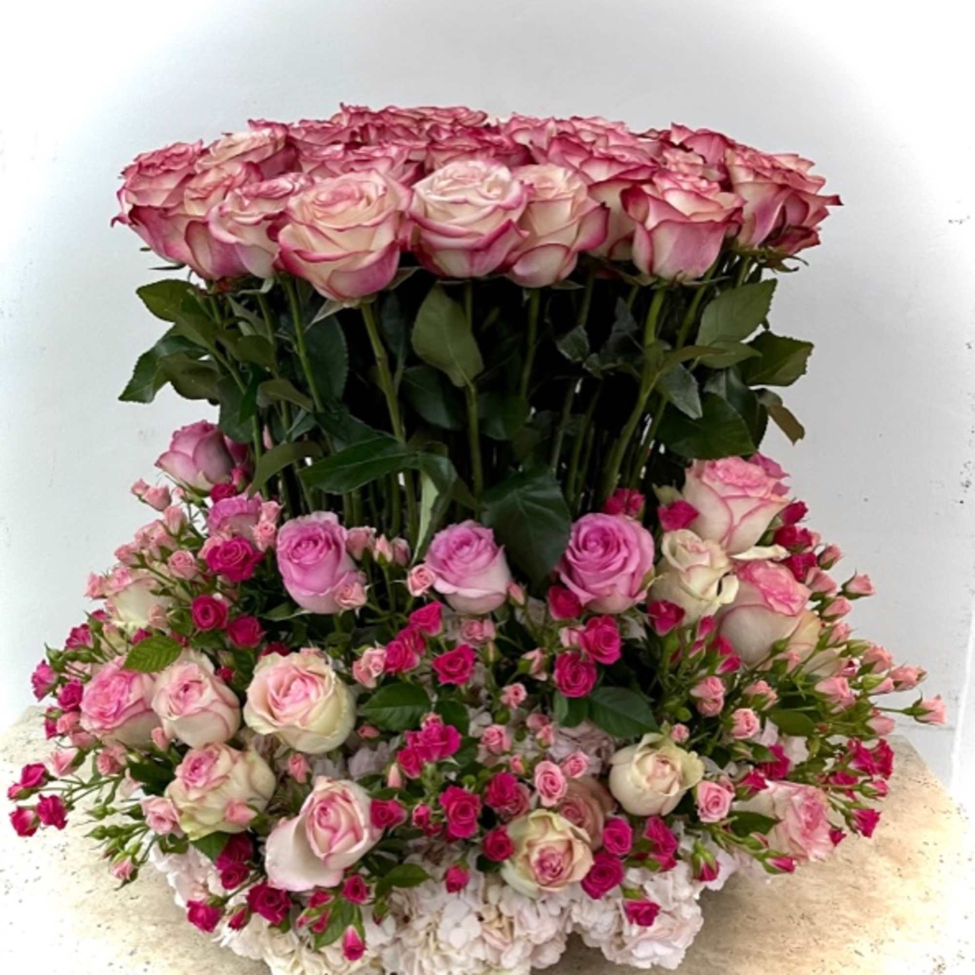 Large pink and white rose arrangement with layered blooms