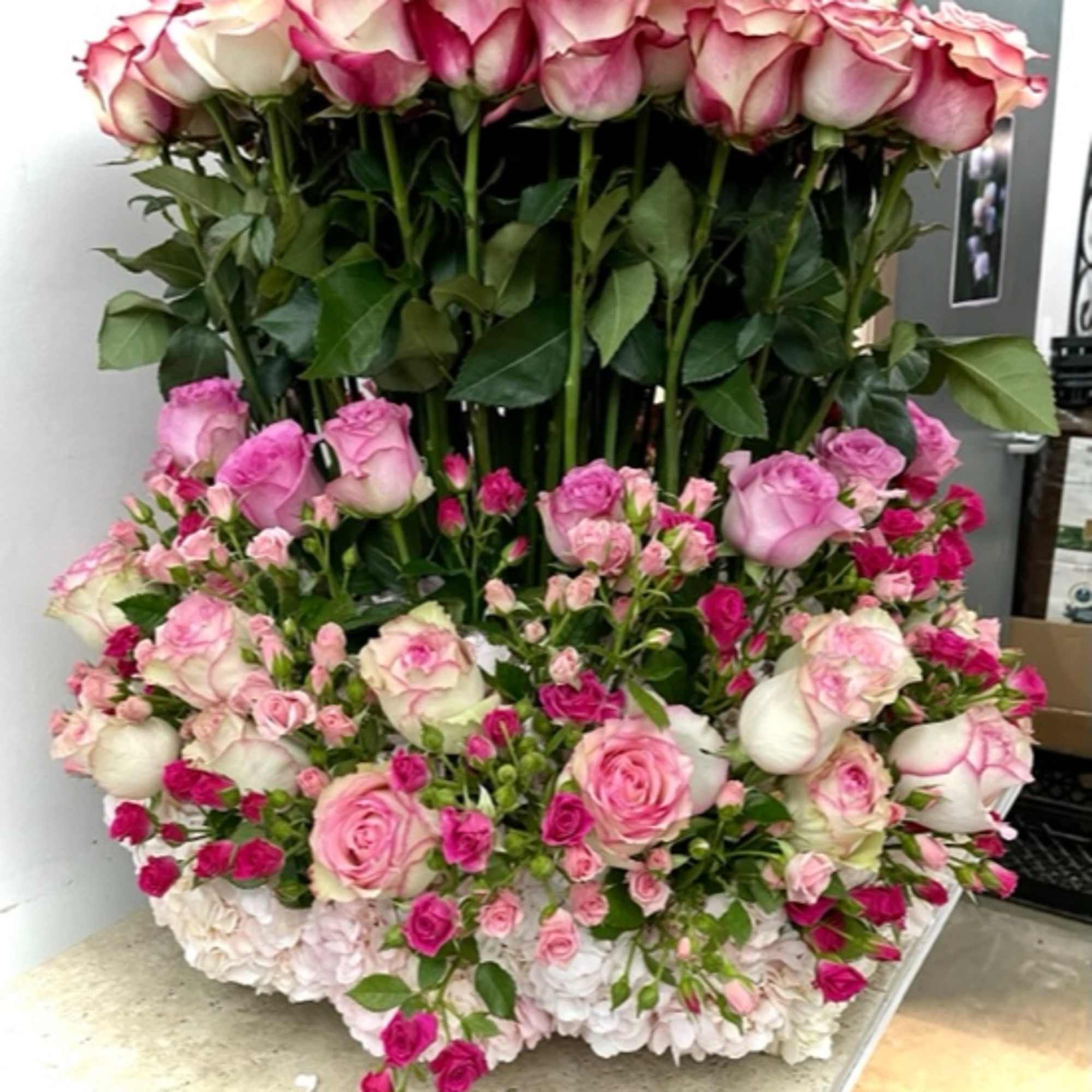 Large pink and white rose arrangement with layered blooms