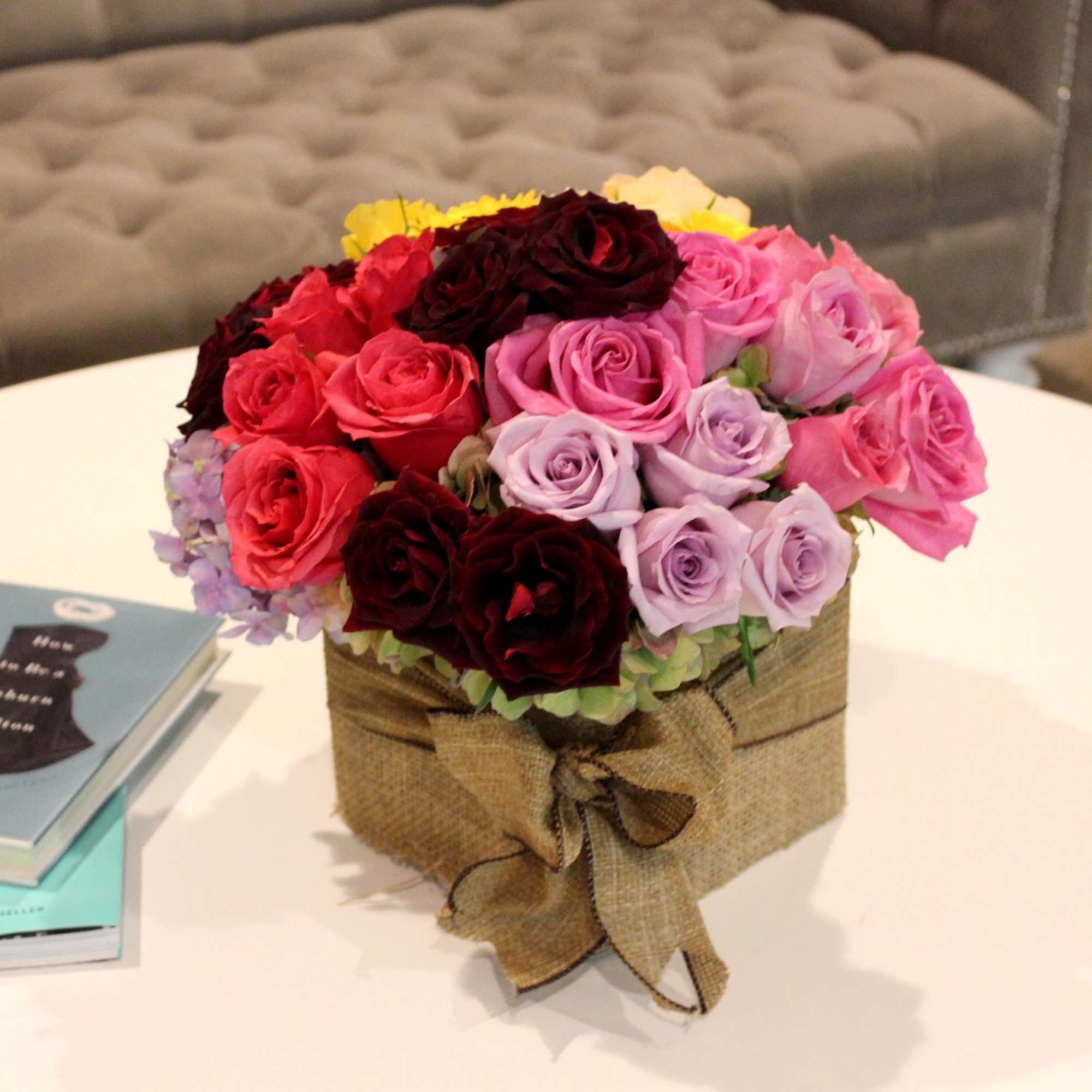 Bouquet of multicolored roses in a burlap-wrapped box
