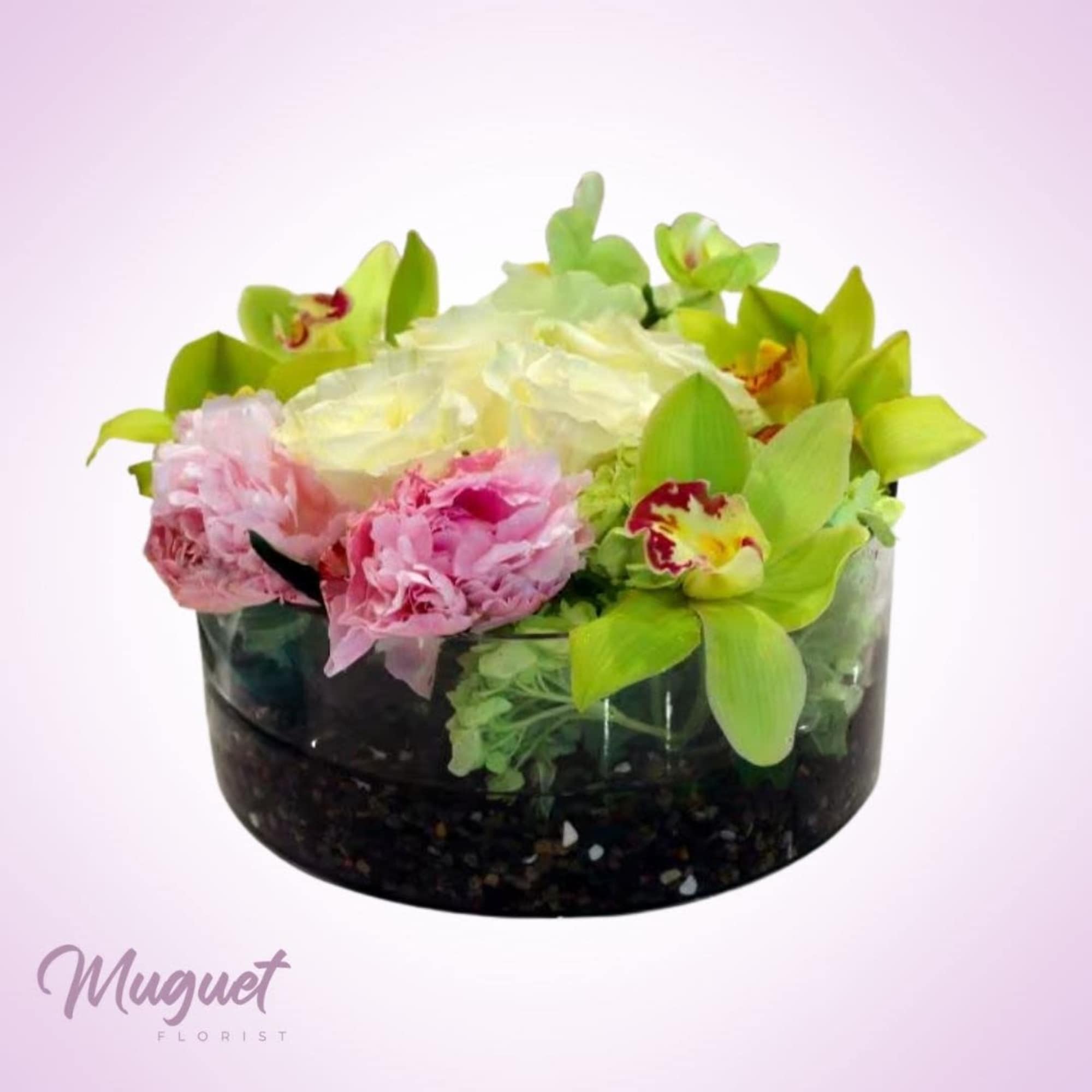 Pink and white flowers arranged in a black glass bowl