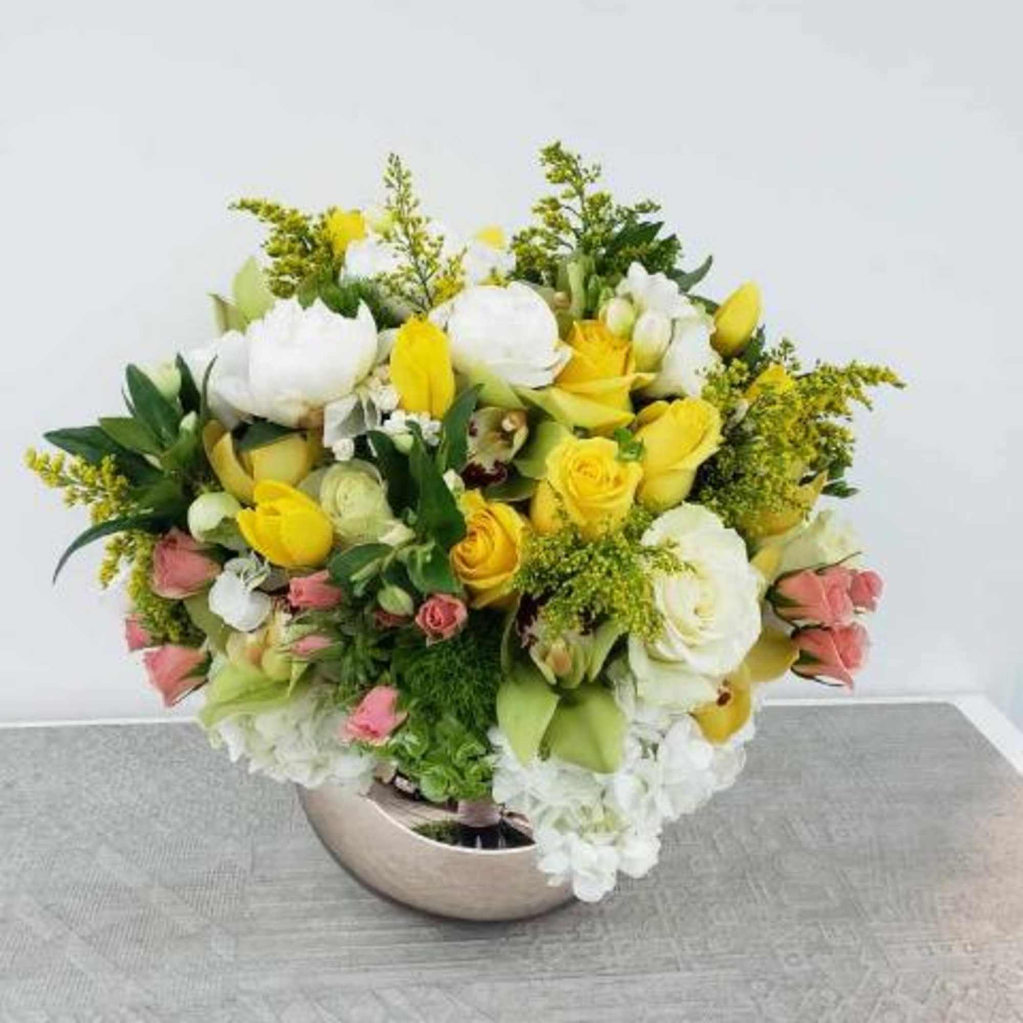 Bouquet of yellow and white flowers in a low vase
