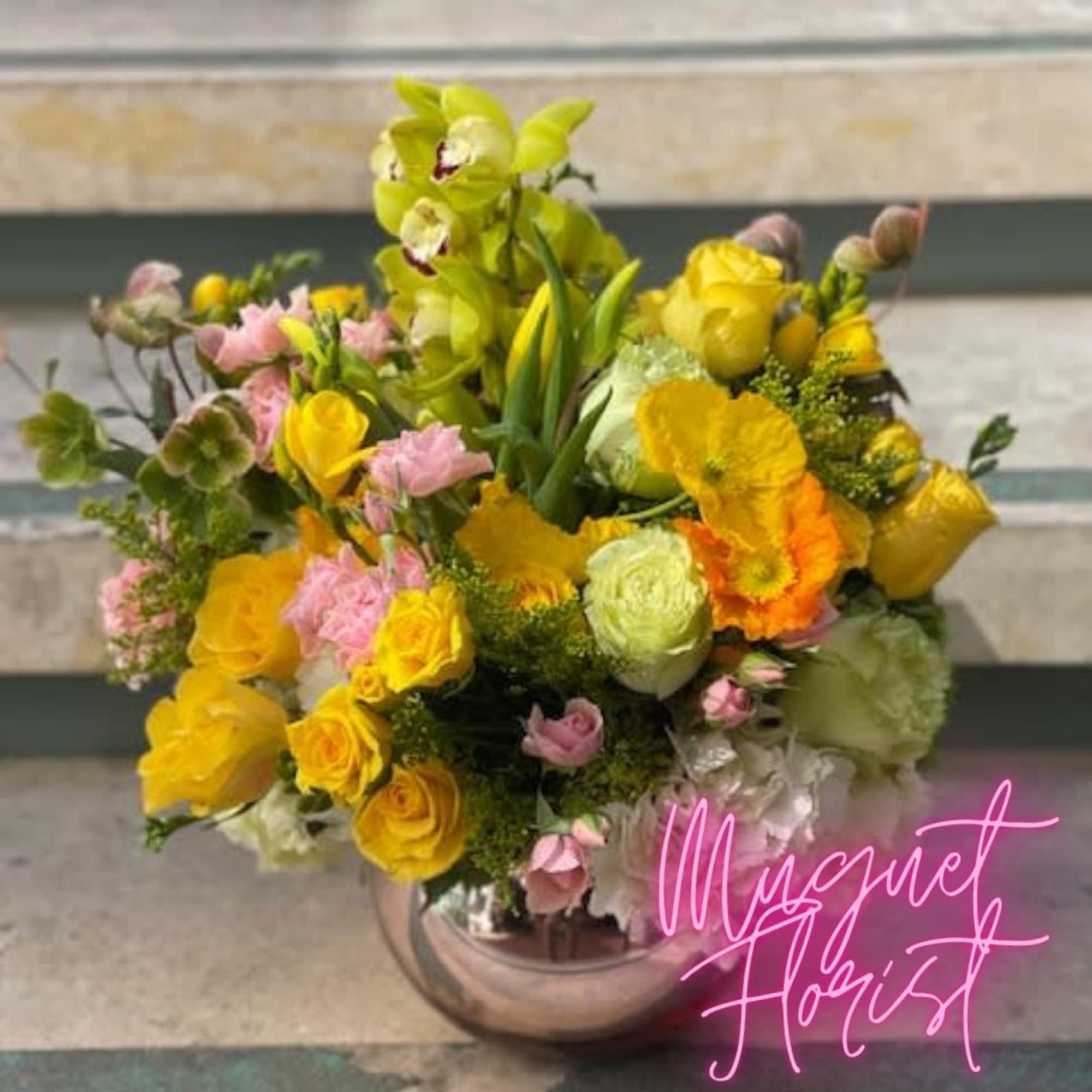 Yellow and pink mixed bouquet in a round glass vase
