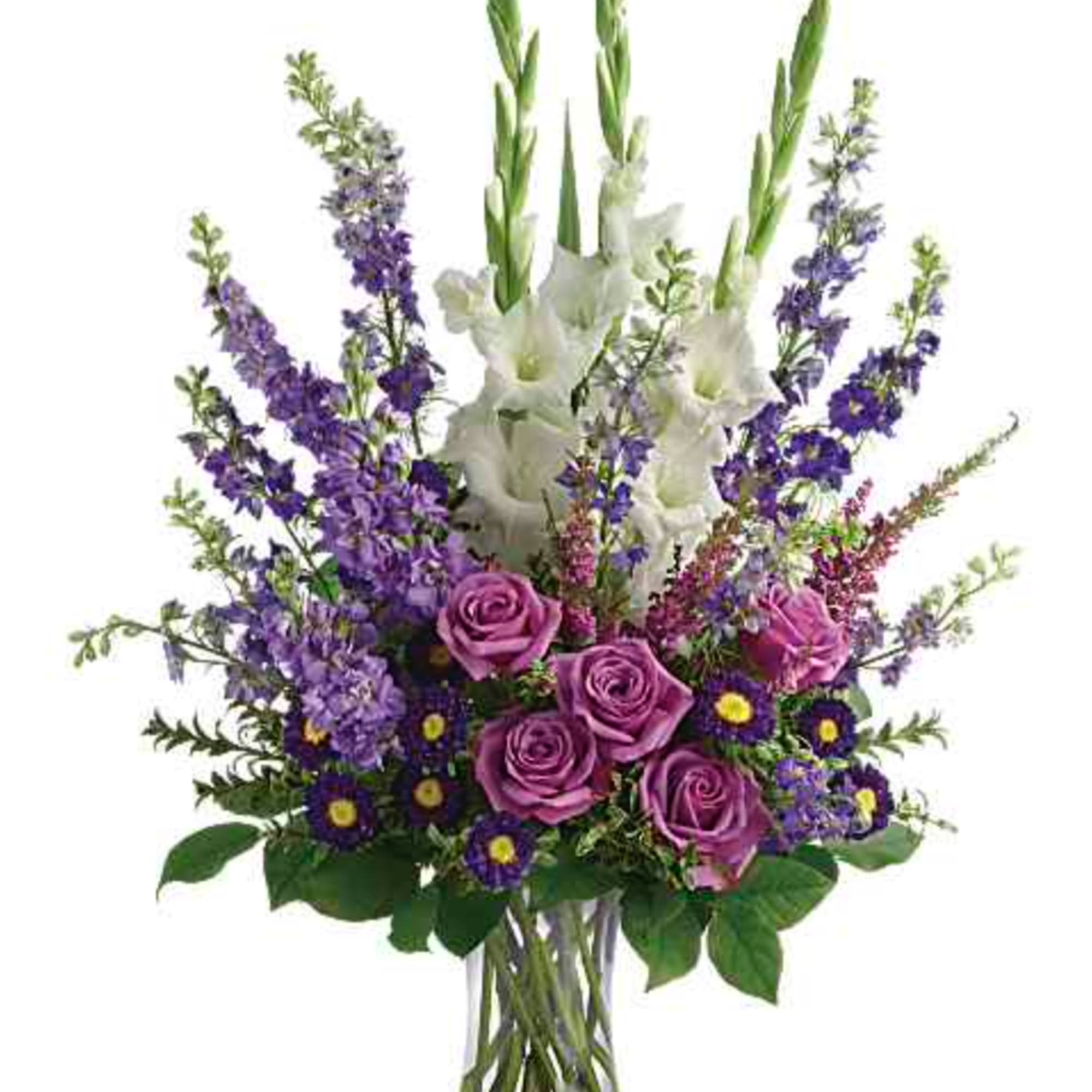Purple roses and white gladiolus in a clear glass vase