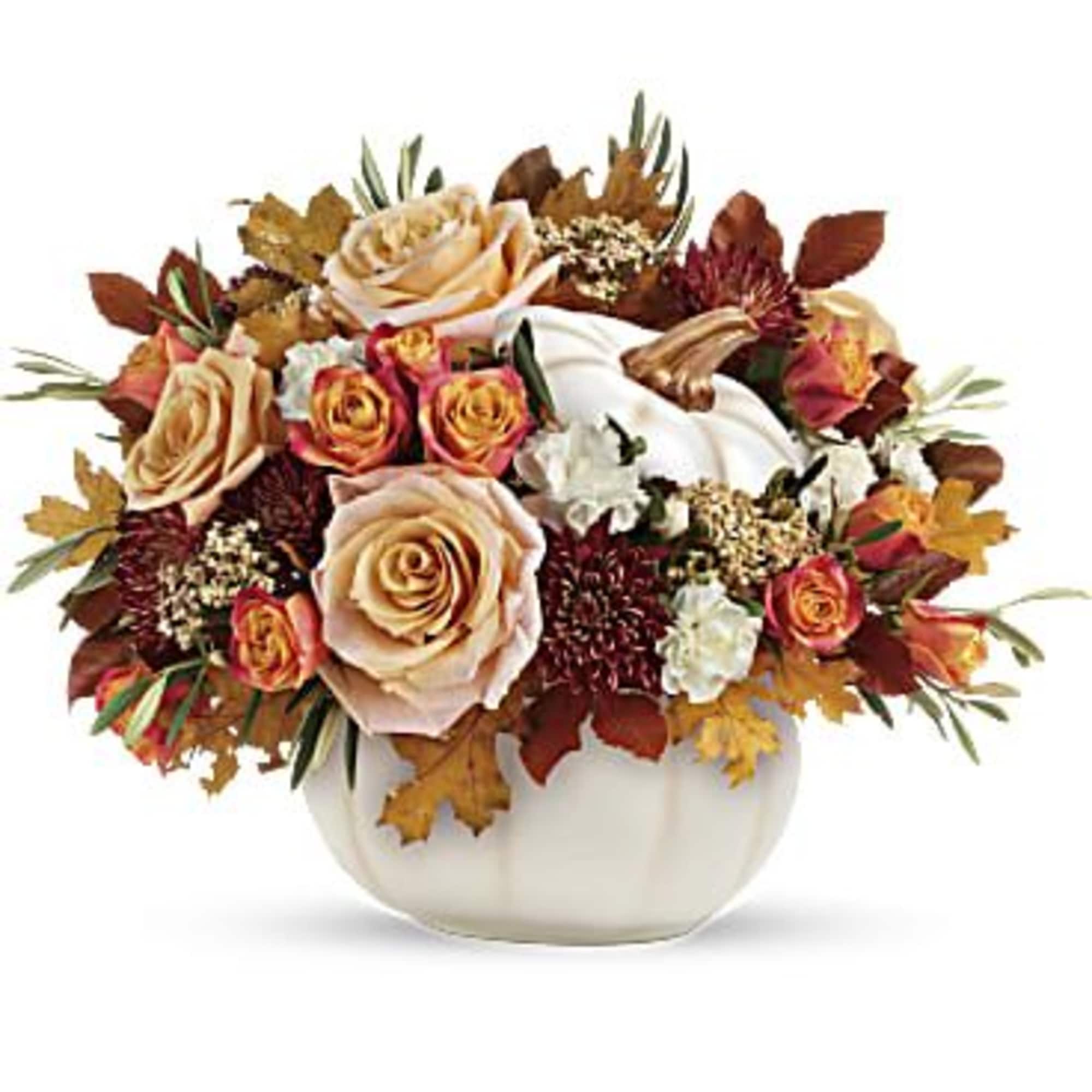 Autumn floral arrangement in a white pumpkin vase with roses and fall leaves
