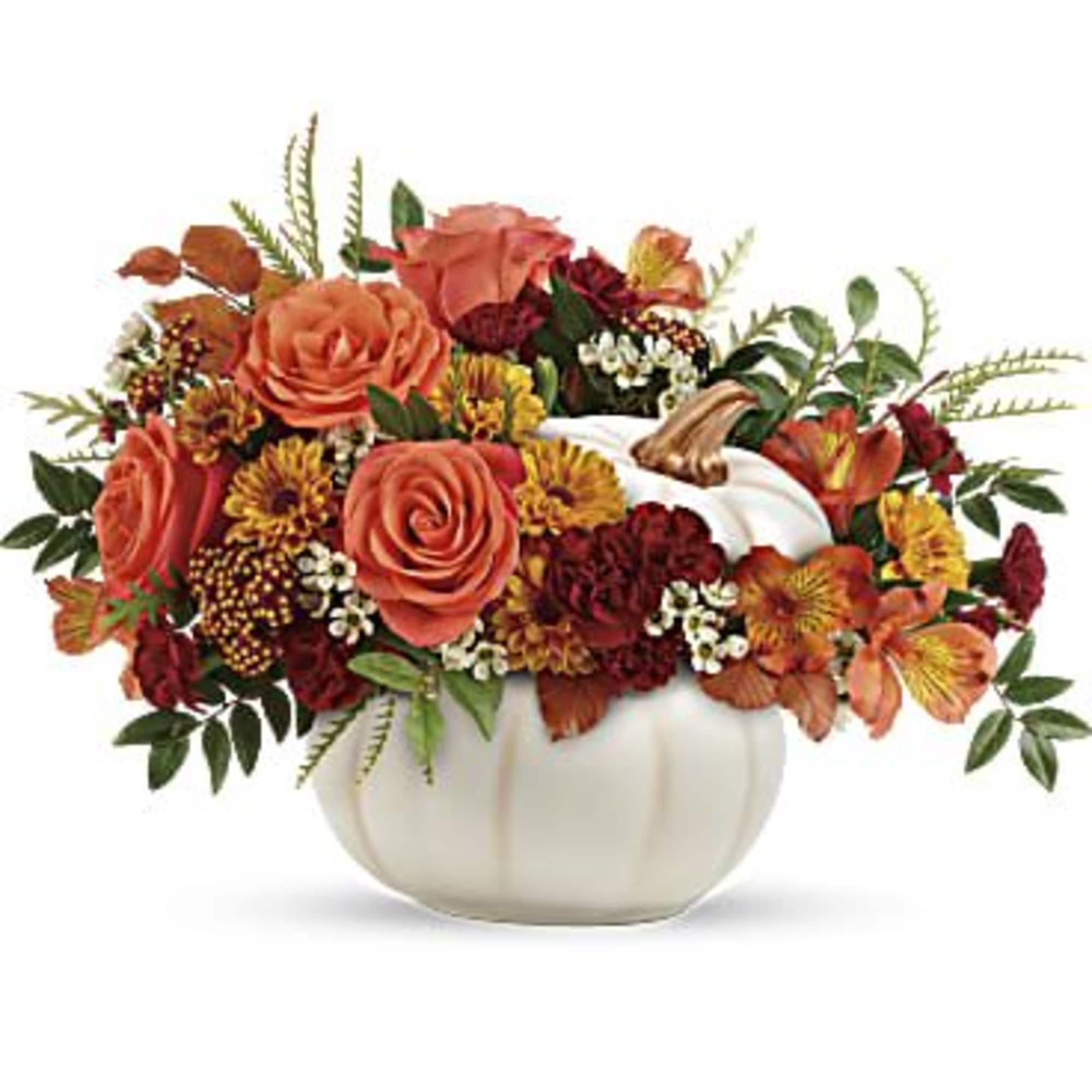 Orange roses and autumn flowers arranged in a white pumpkin vase
