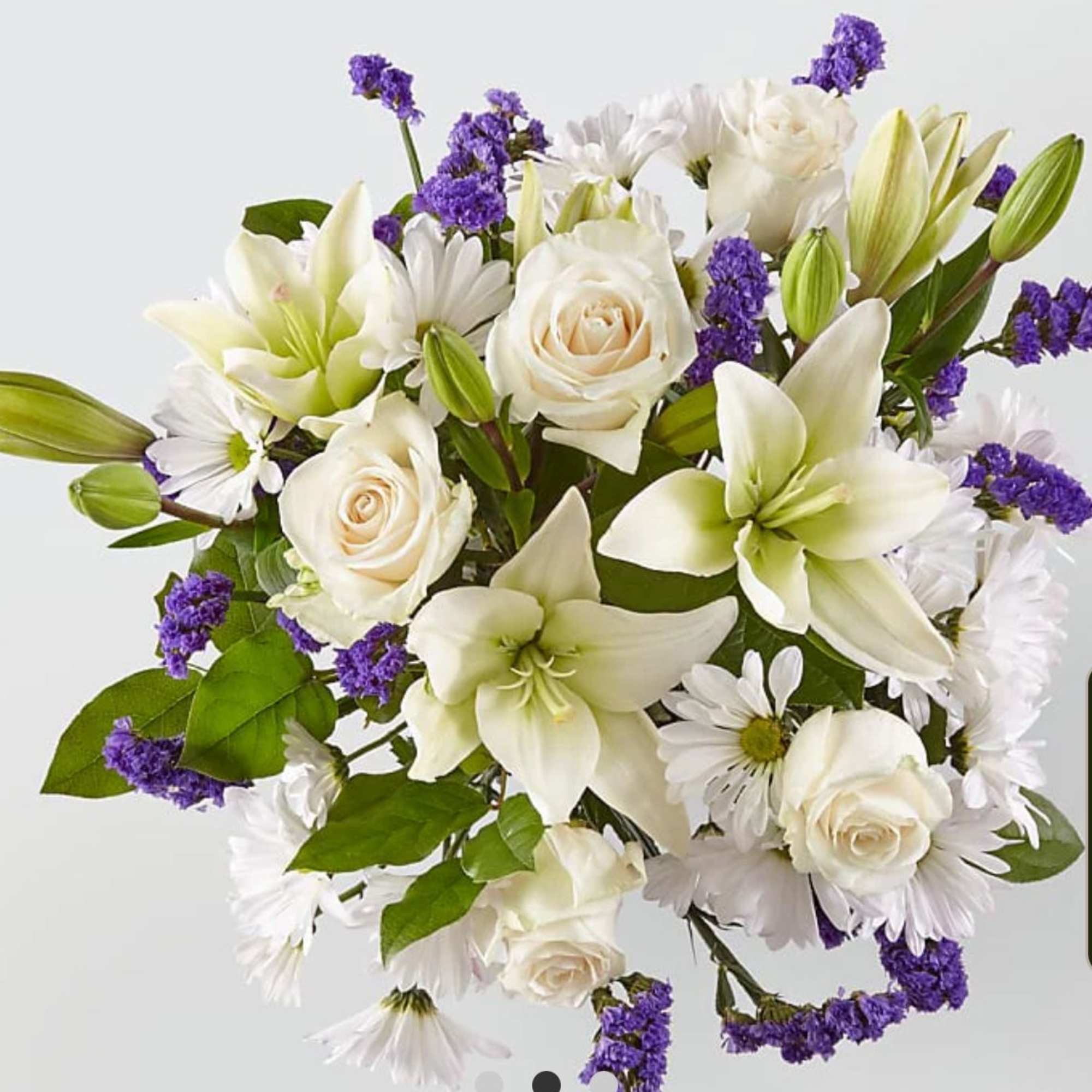 Bouquet of white lilies, roses, and daisies with purple accents