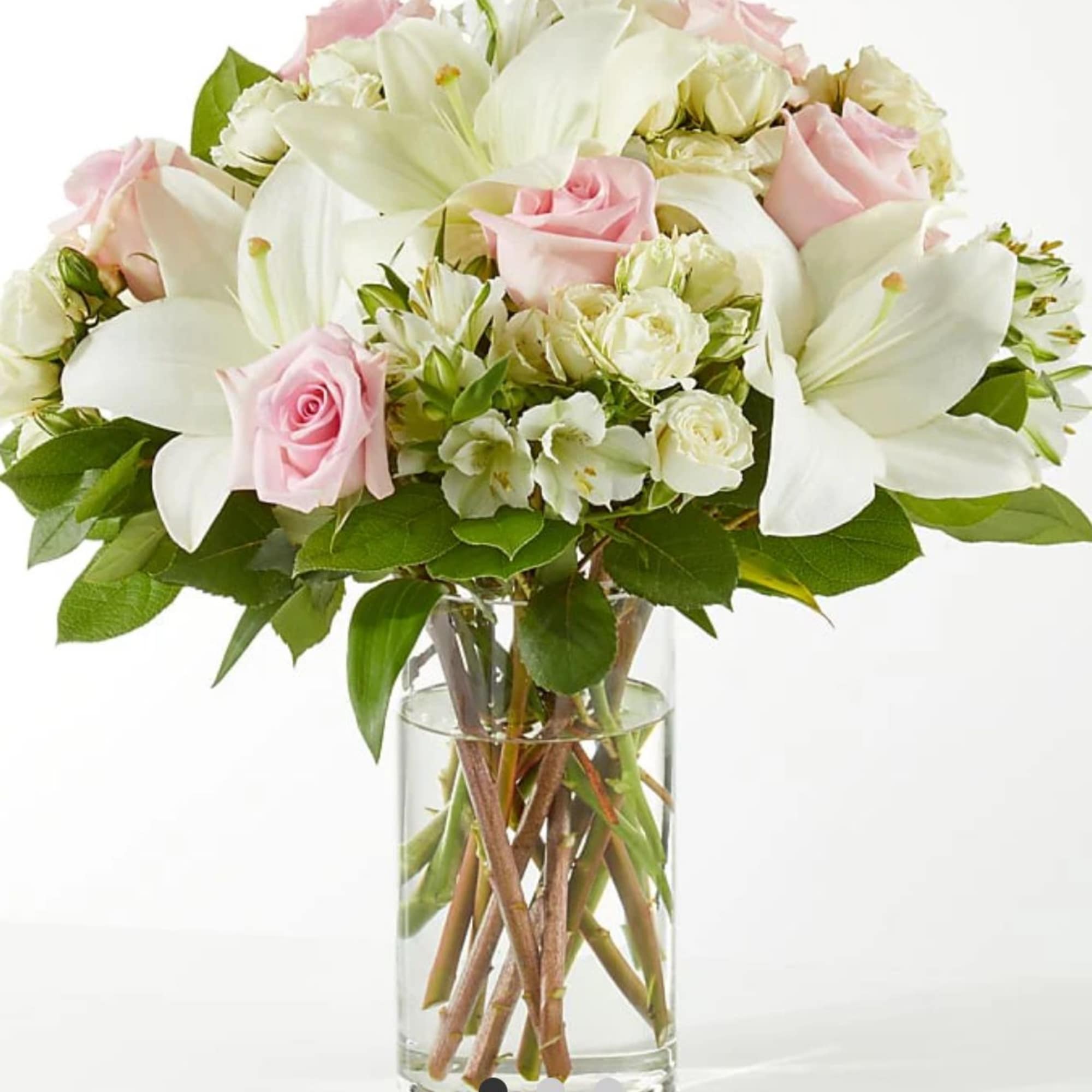 Pink roses and white lilies arranged in a clear glass vase