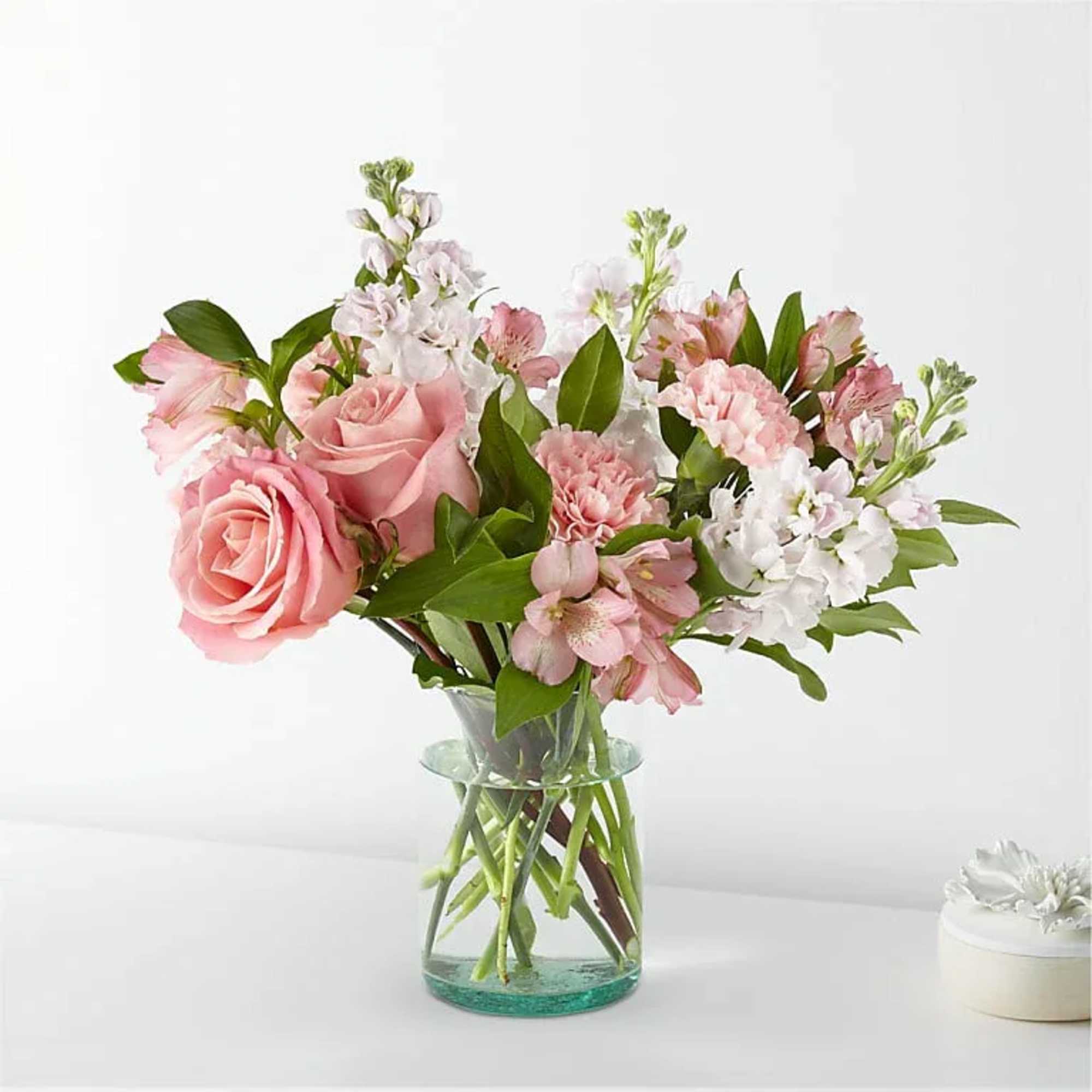 Pink roses and mixed pink-white flowers in a clear glass vase