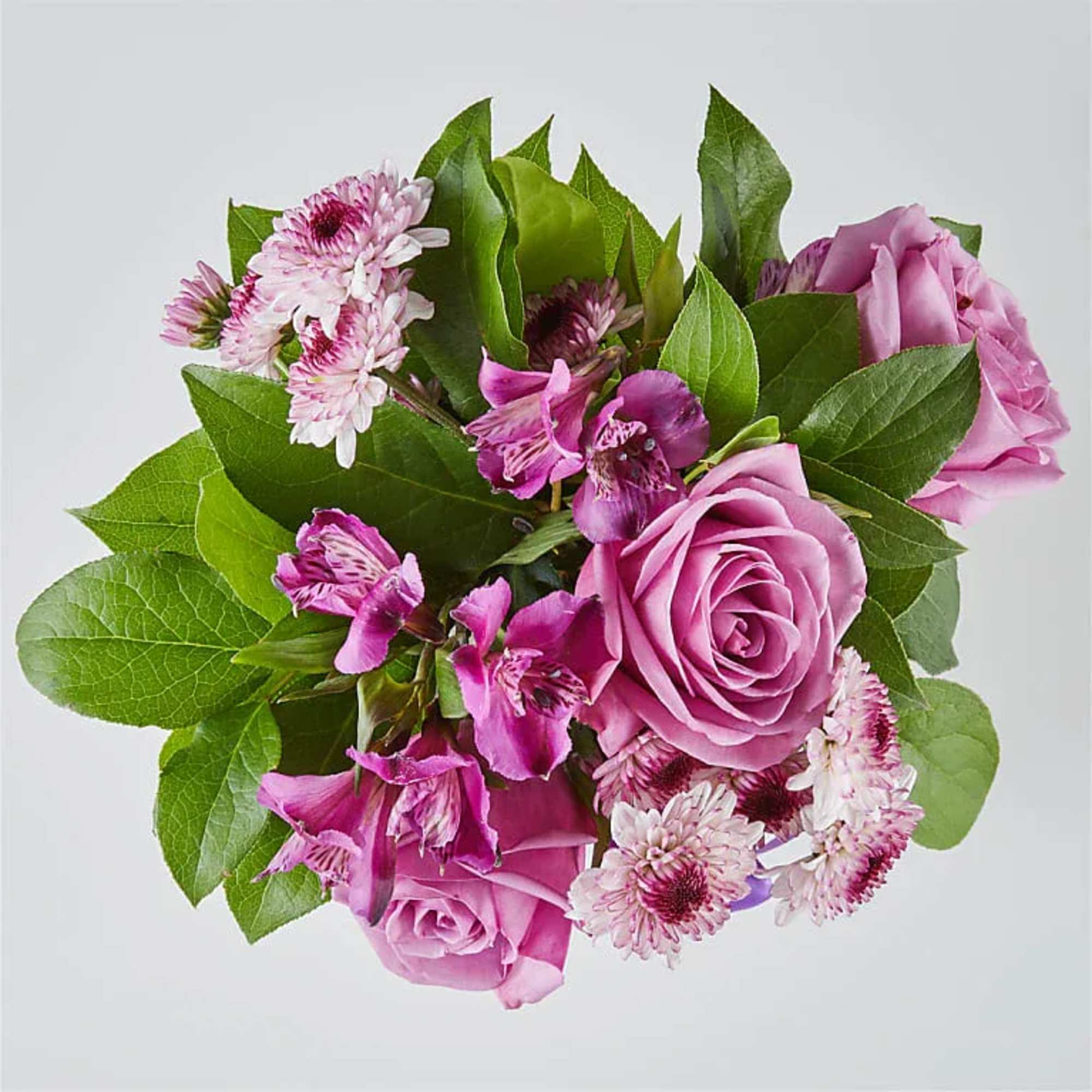 Pink roses and small purple flowers in a compact bouquet