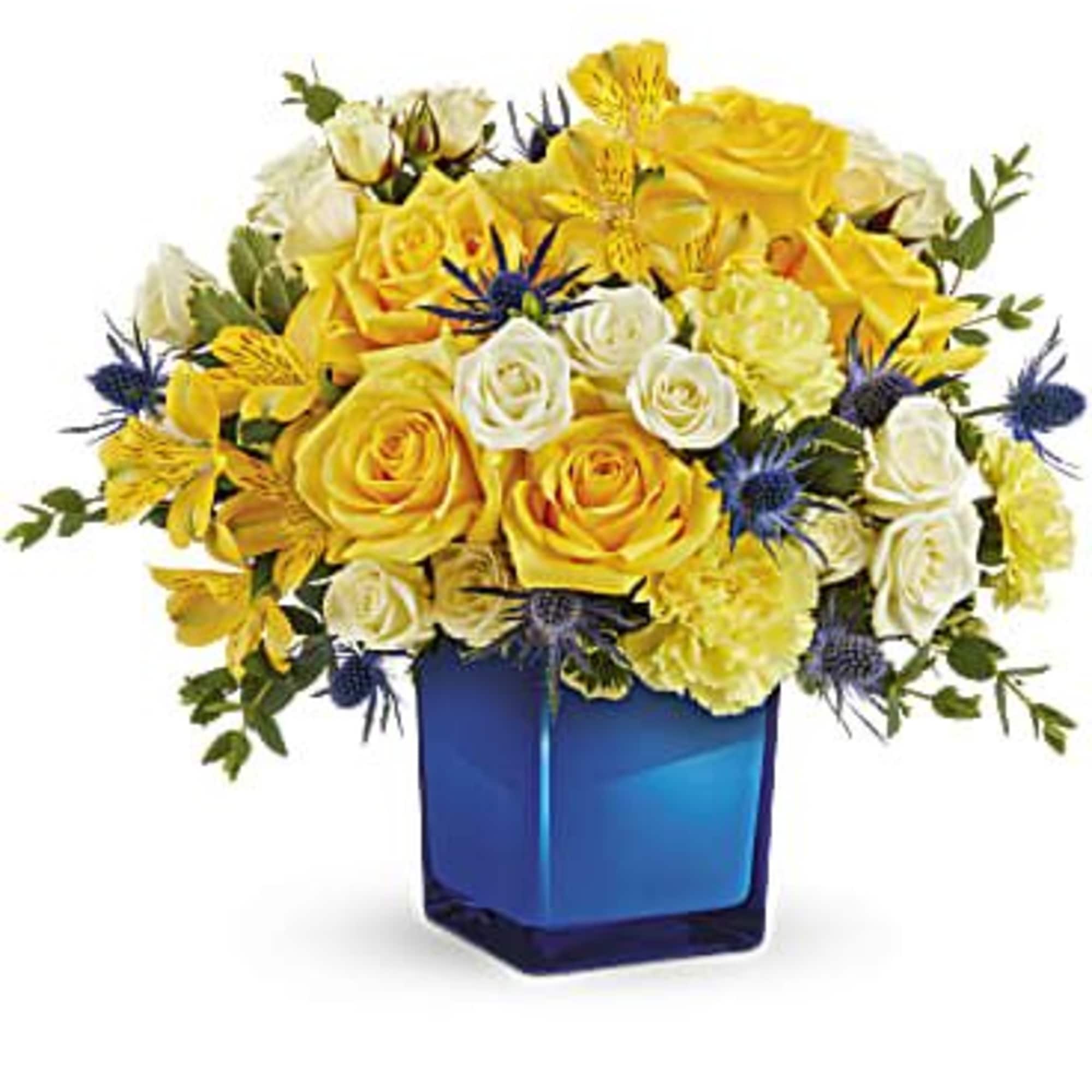 Yellow and white roses in a blue glass vase